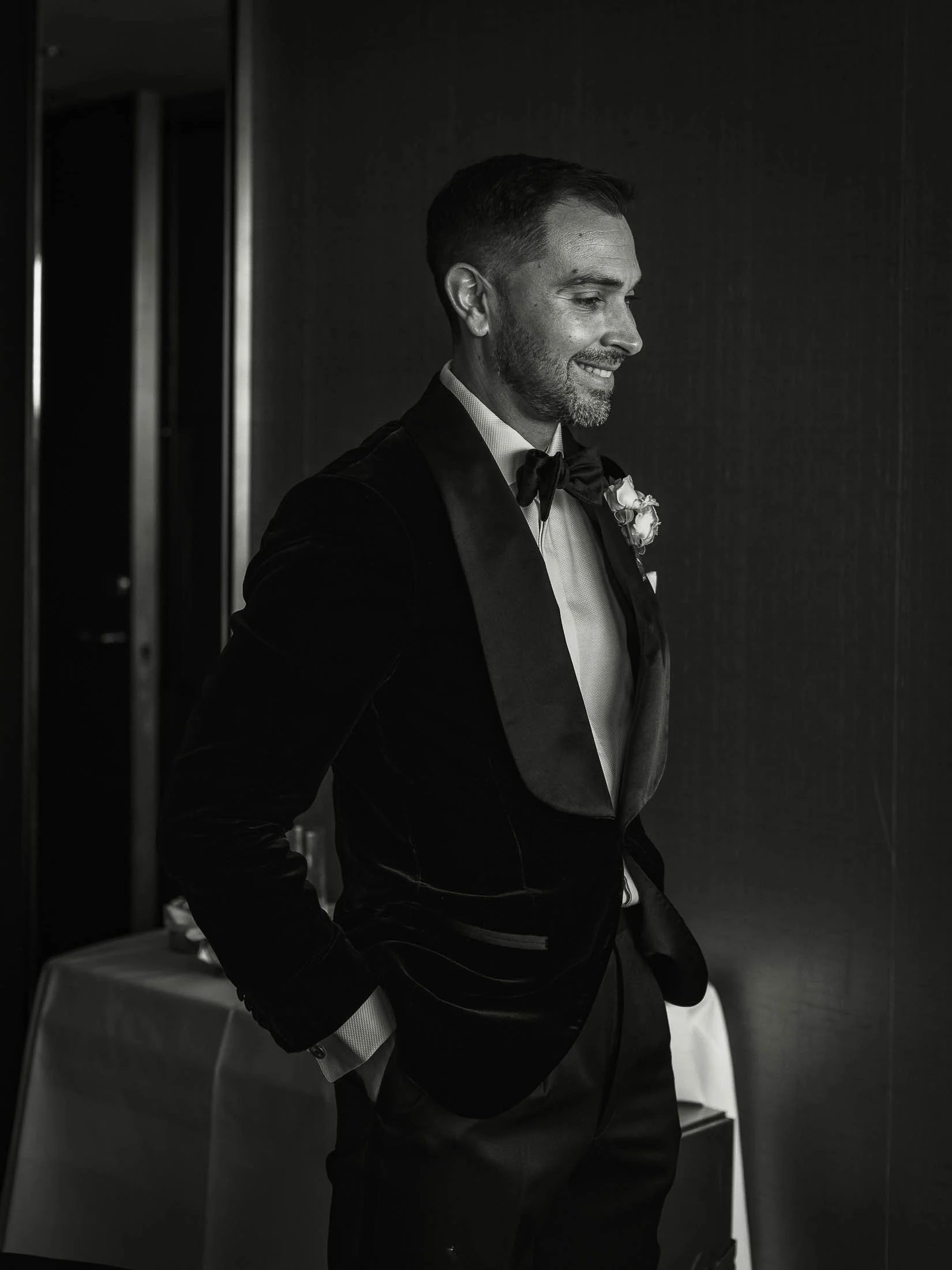 A groom smiles during morning preparations for his formal black tie London wedding at The Shard.