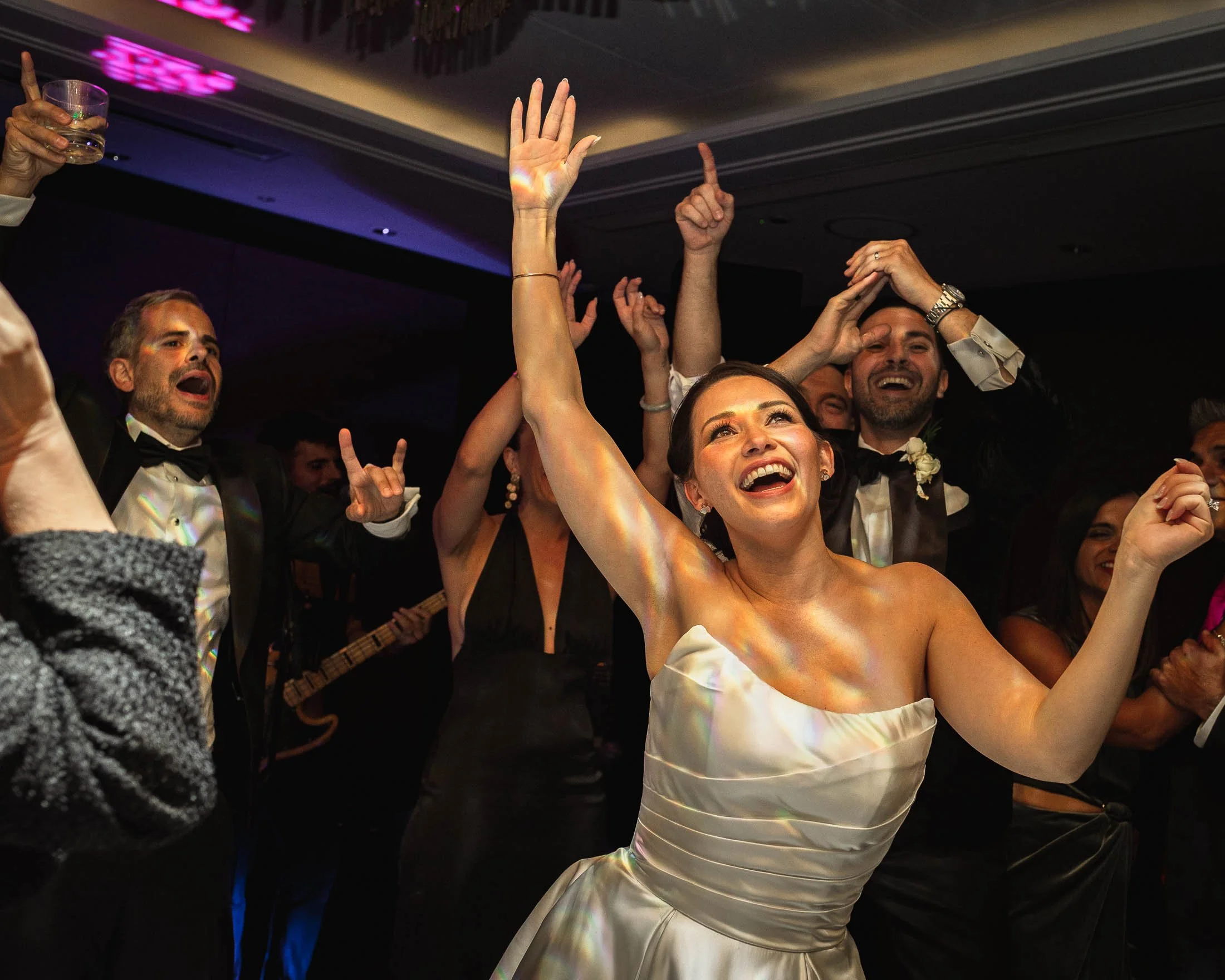 A bride laughs and dances energetically on the dance floor at the Shangri-La The Shard hotel in London.