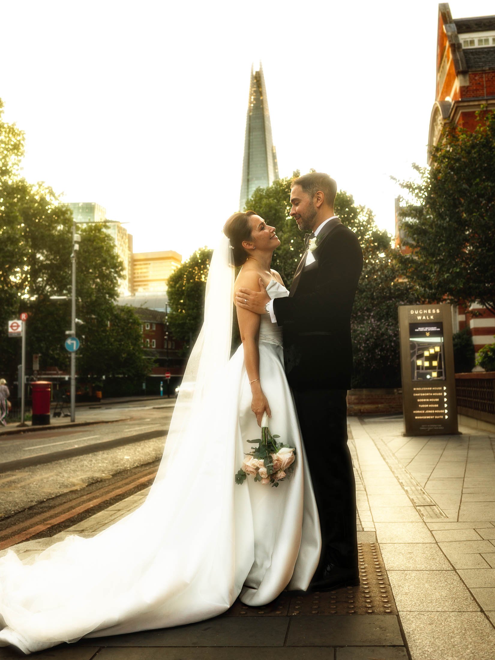 An editorial London wedding photograph showing a couple posing during golden hour on their black tie wedding day, with The Shard in the background.