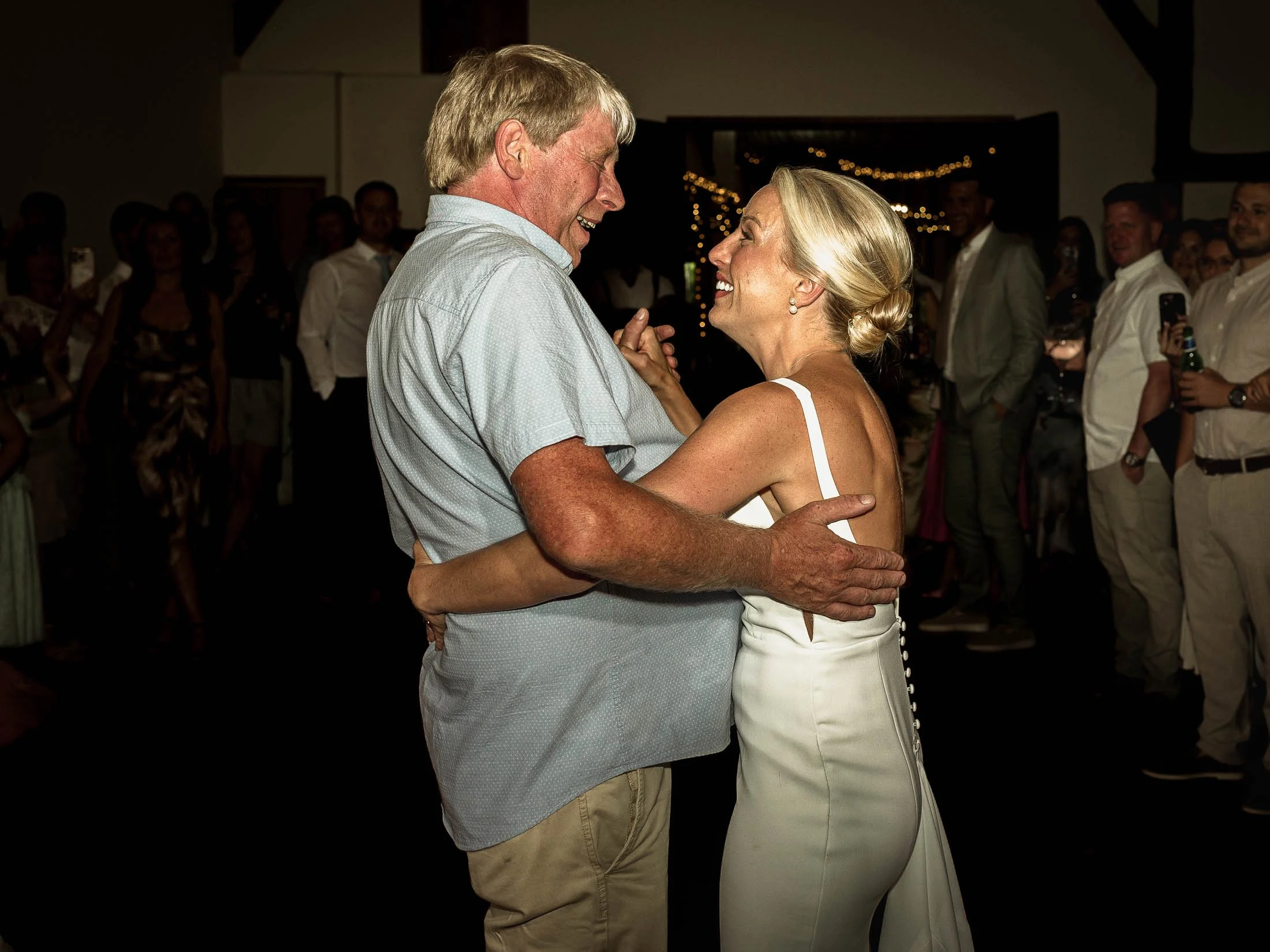 A natural wedding moment as a bride dances with her father on the evening of her summer wedding day at Winters Barns in Kent.