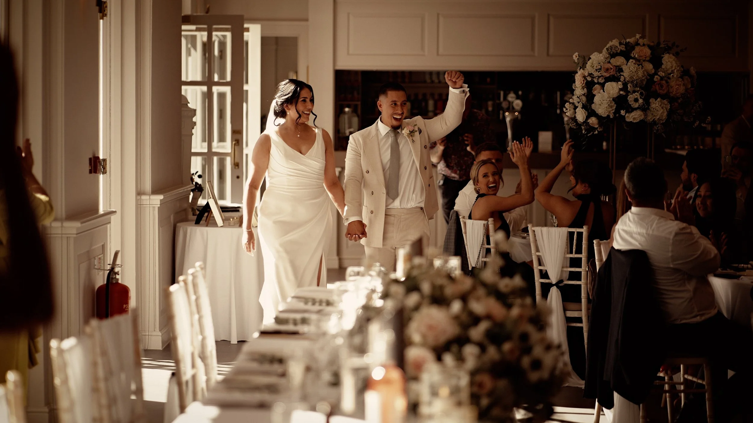 Couple enter their wedding breakfast after their lakeside Lapa wedding ceremony at The orangery, Maidstone