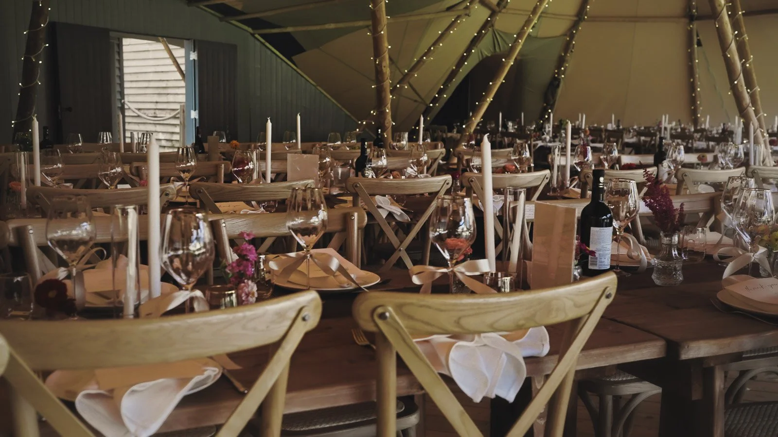 Details of tables, flowers and glassware at a colourful riverside wedding in the UK.