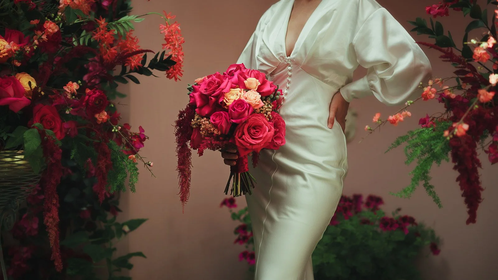 Bridal detail shot showing simple dress and refined styling coupled with bold bright pink florals.