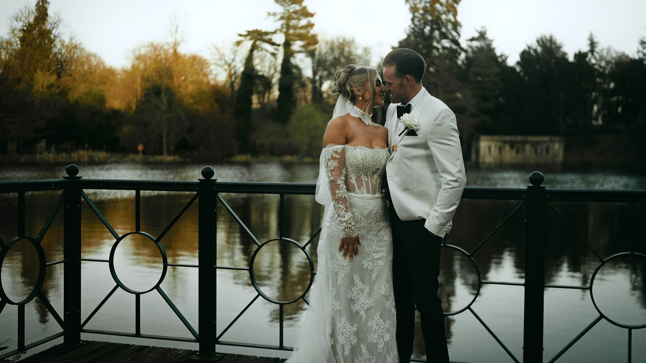 A couple stand by the lake at The Orangery Maidstone during golden hour, a moment of high emotion and reflection during the cinematic wedding film.