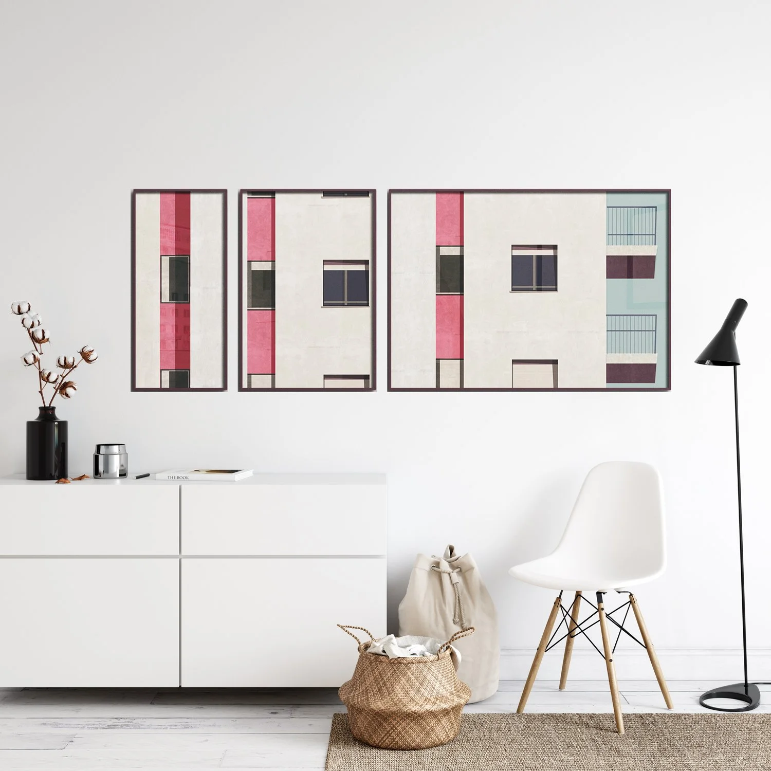 Modern interior room with white furniture, potted cotton plant, and three-panel abstract artwork of a building facade with pink, white, and dark accents on the wall.
