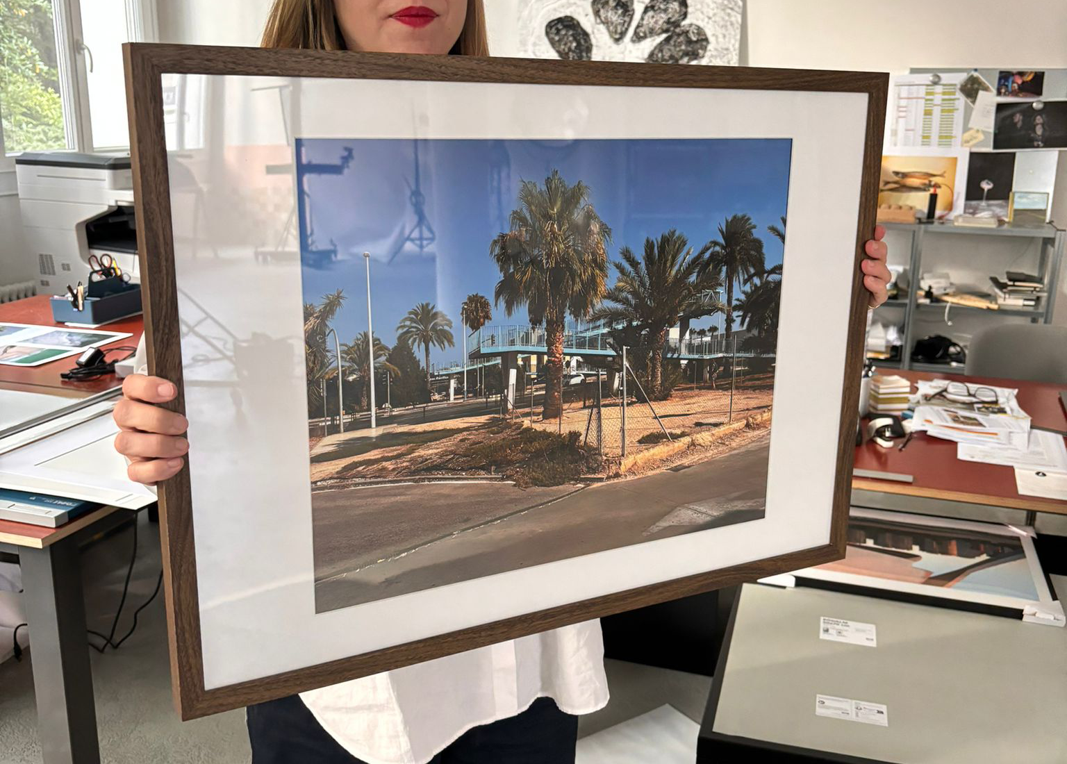Person hält gerahmtes Foto von einer Palme an einem Strandausflug bei perfektem Wetter.