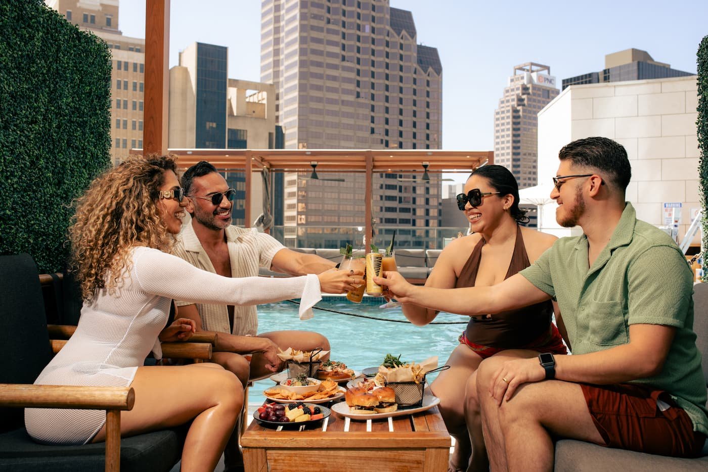 group of people near a pool having drinks and food.