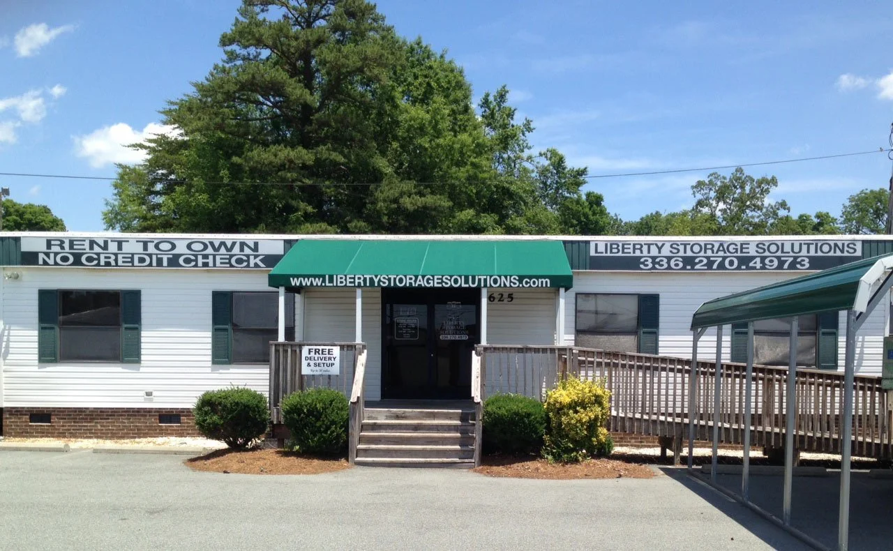 The Liberty Sheds office in Burlington, NC with a green awning and wood ramp.