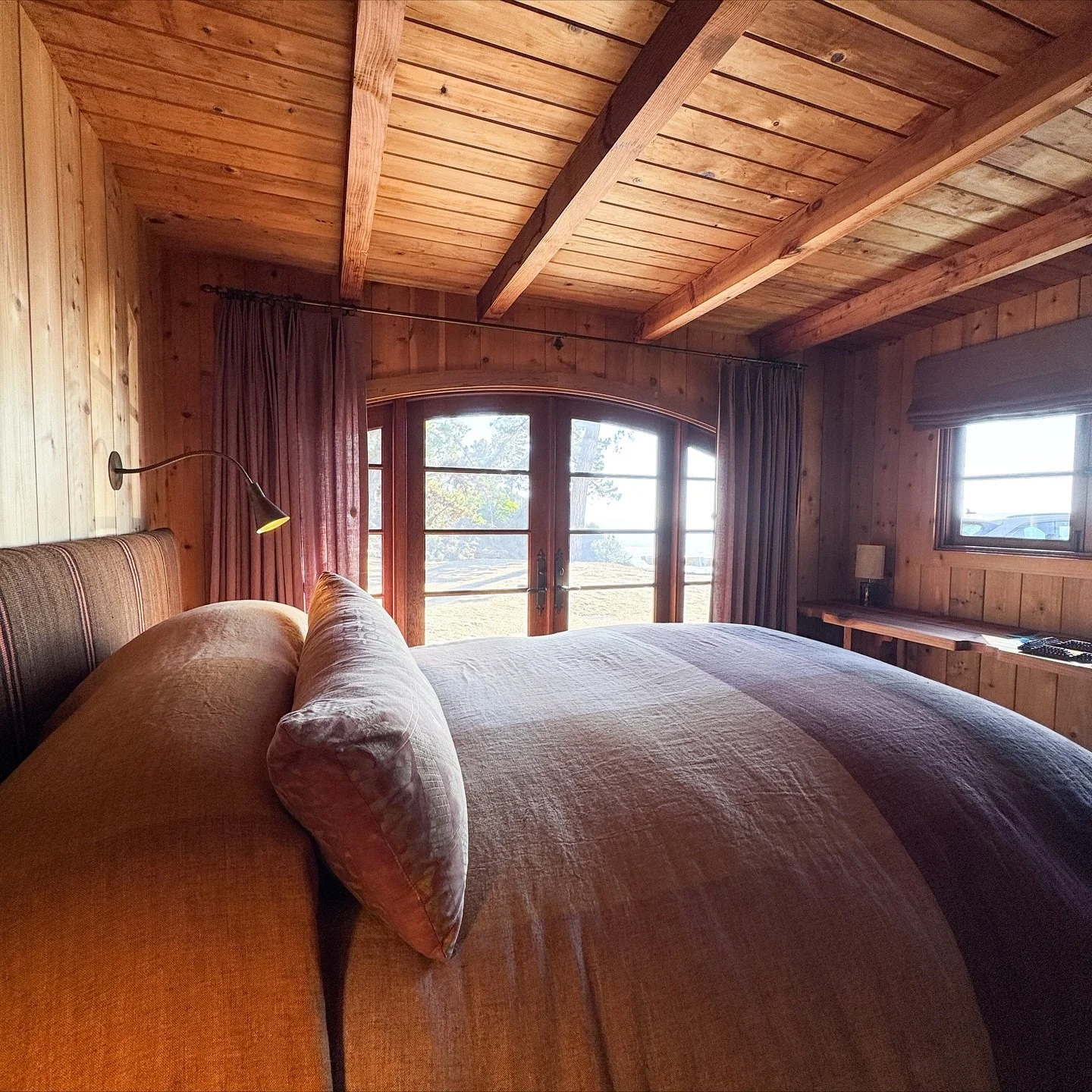 Big Sur cottage pt. II. Moody linen drapery and a flat front Rom&aacute;n shade in this guest bedroom.  Analog functionality and natural materials, with a touch of technology with the motorized roller shades for some hard to reach clerestory windows 