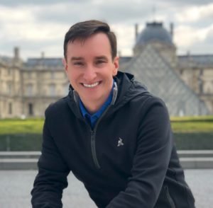 Man smiling at camera with jacket on.