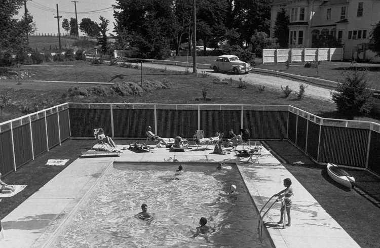 Historical black and white of Chevy Chase Beach Cabins Pool with swimmers and sunbathers