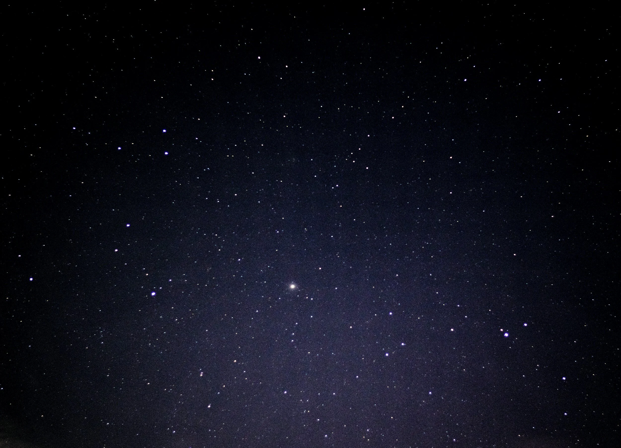Star-filled night sky with various bright stars scattered across a dark backdrop.