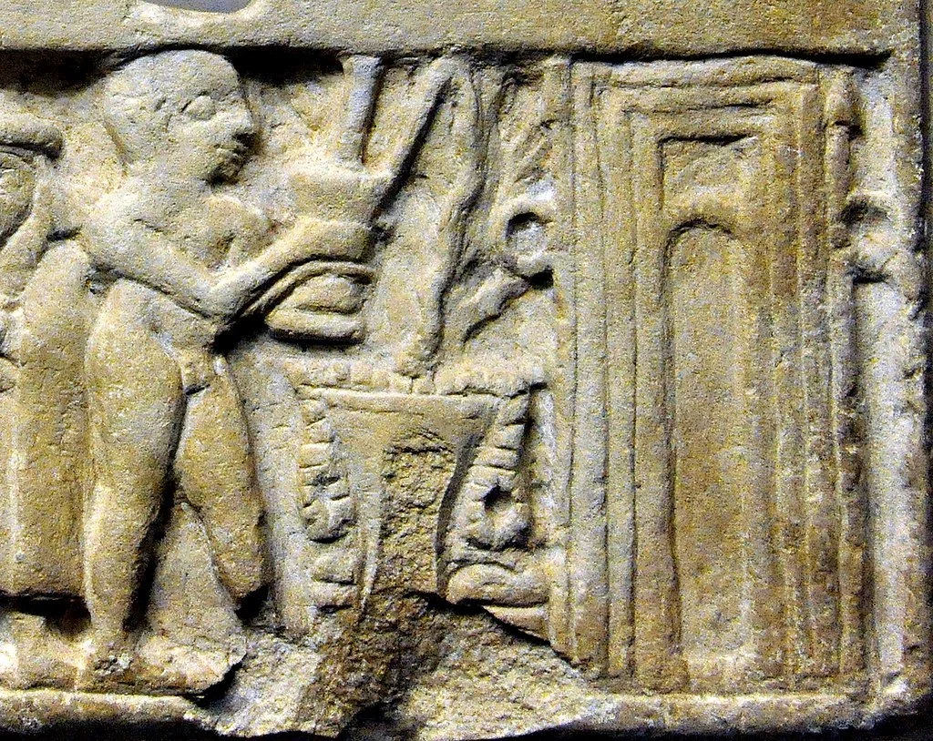 Ancient stone relief depicting a person with tool