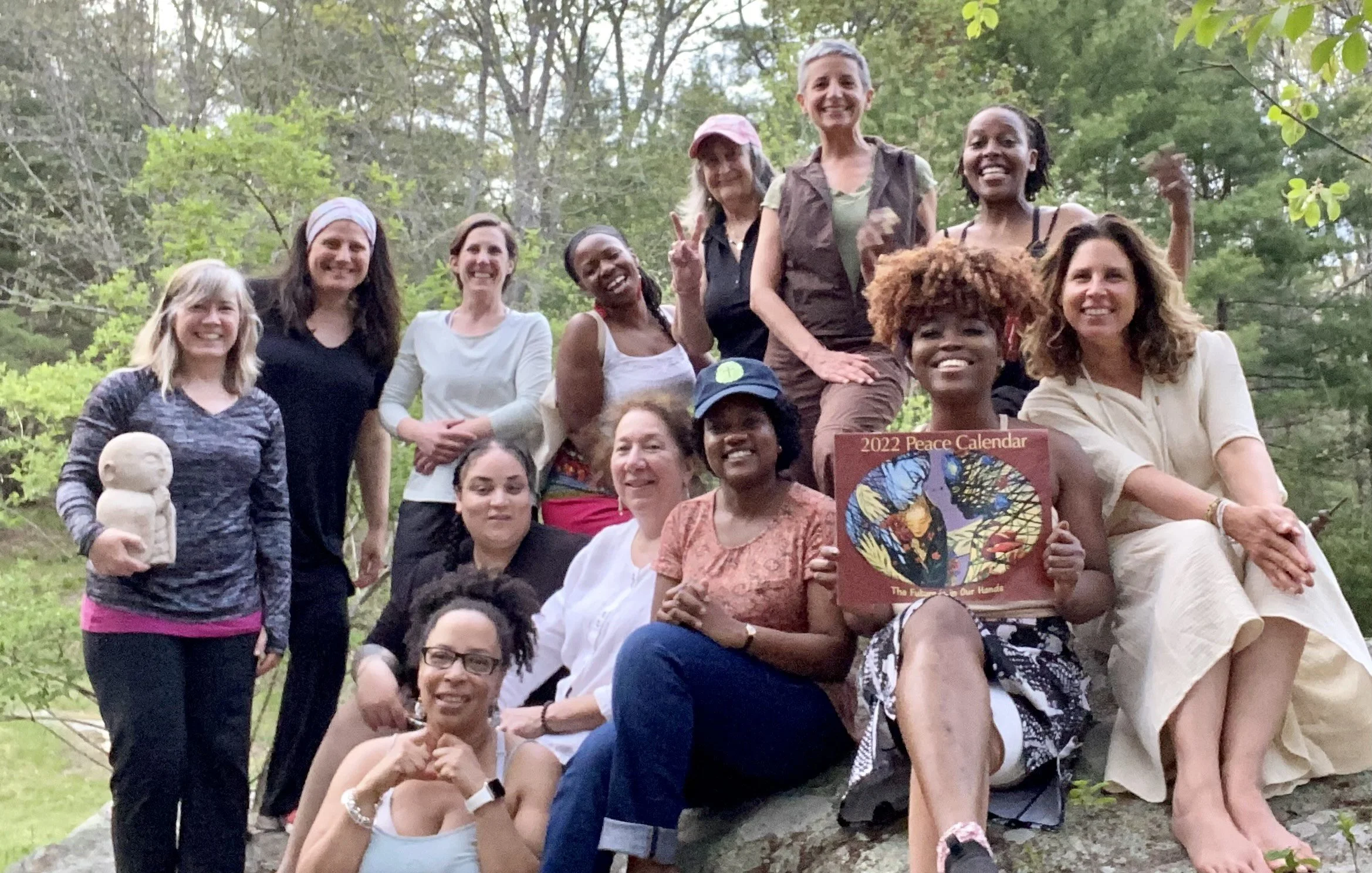 Group of thirteen people wearing casual and sports attire and smiling