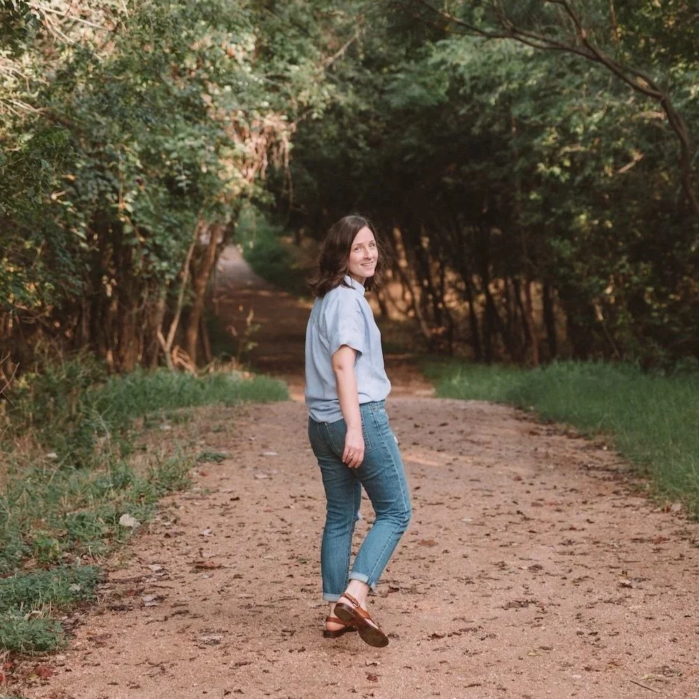 Sister Seasons' founder Rebecca Magee walks down a path towards a grove of trees.