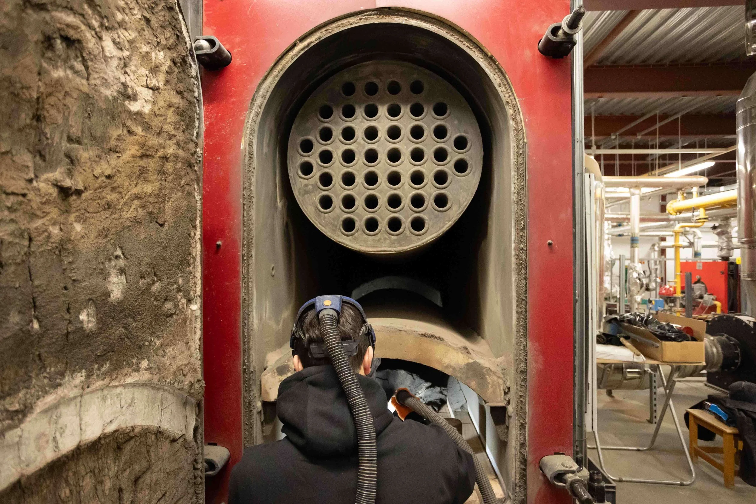 BBS engineer cleaning out biomass ash with full safety gear on