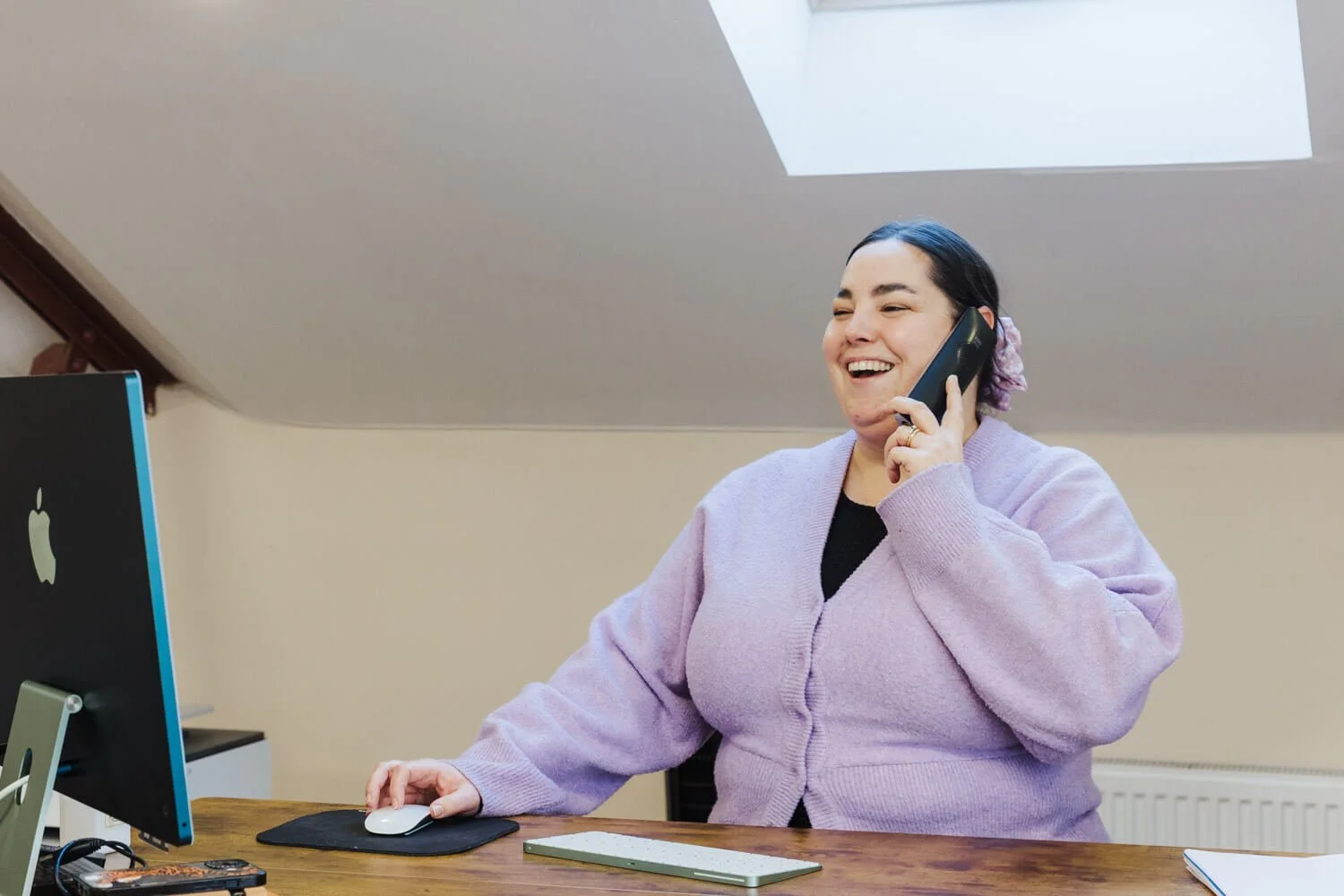 office manager answering telephone and smiling