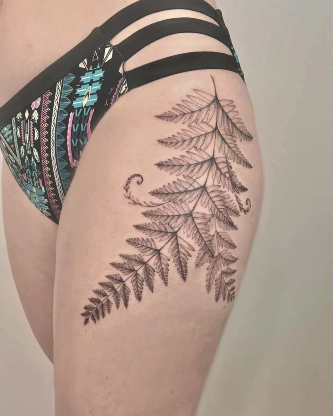 Fern Fineline botanical tattoo on a thigh 