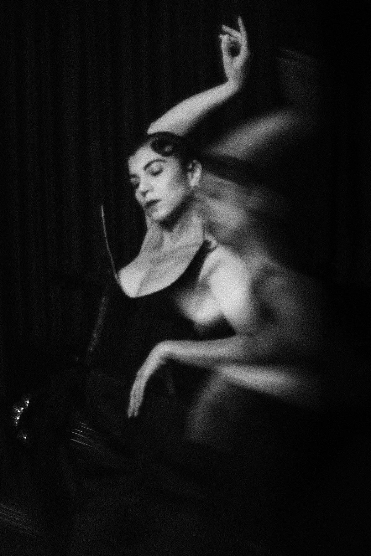 Black and white motion blur portrait of Sorina Rotaru mid movement, arm raised, glass distortion photography