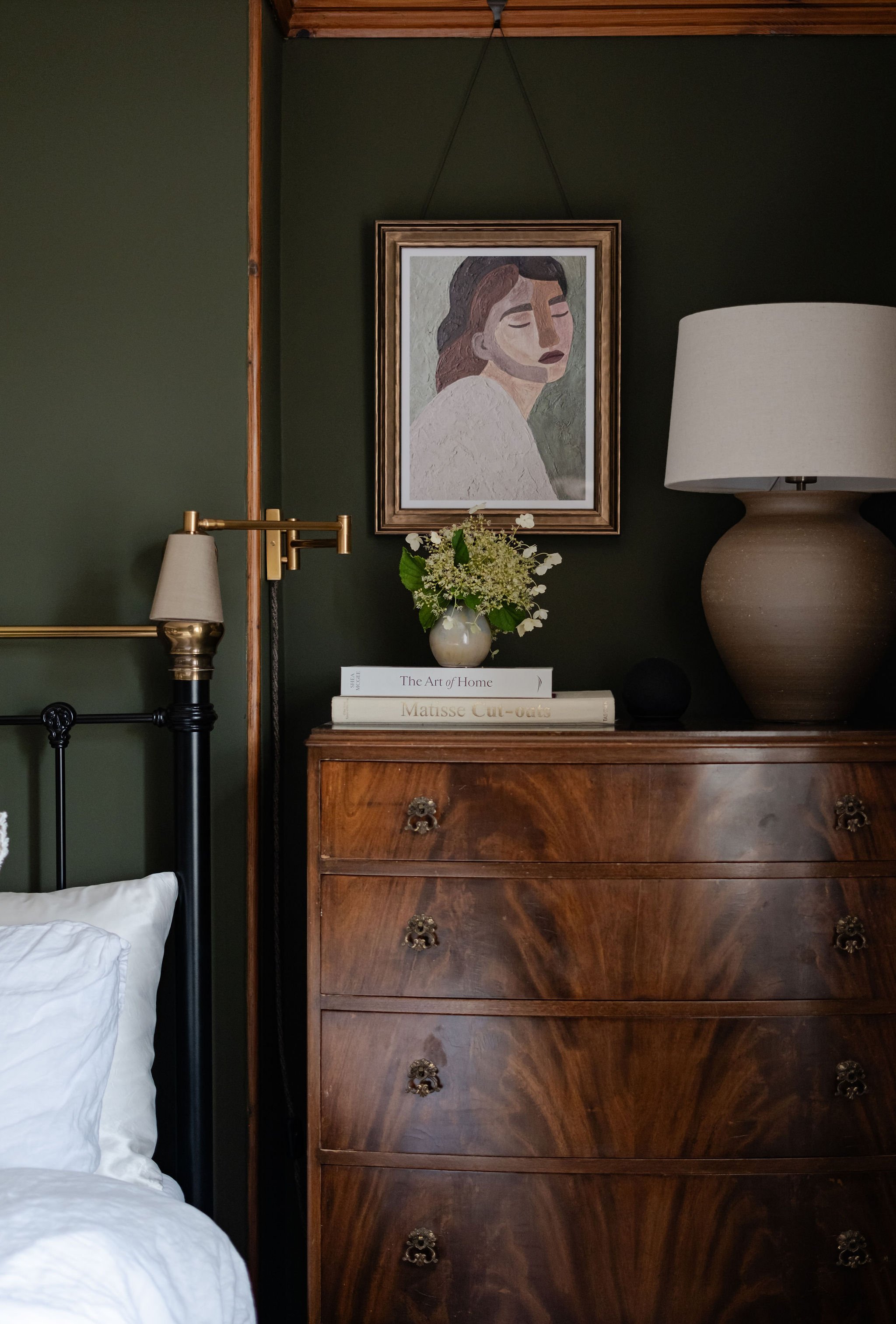 Side of bed vignette vintage chest of drawers portrait and stoneware vase