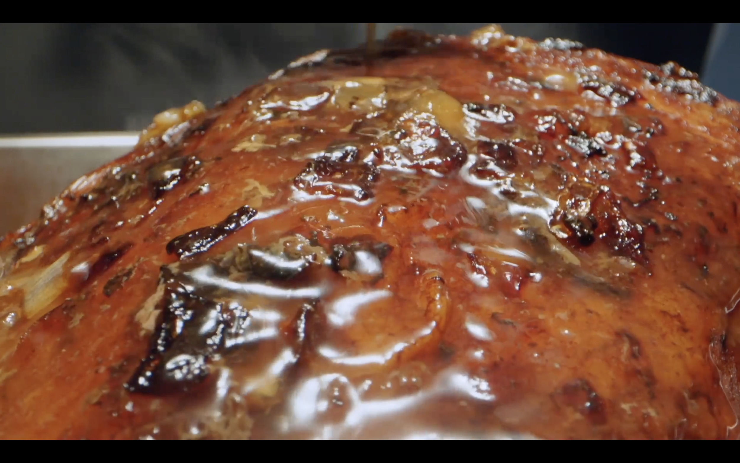 Close-up of a glazed roasted ham being cooked