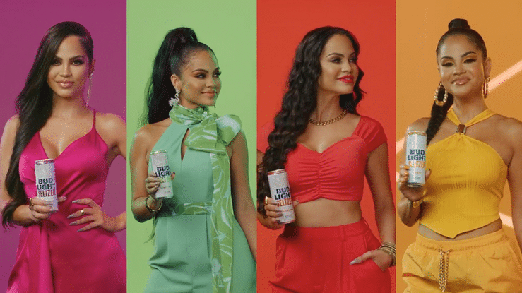 Four women in colorful outfits holding Bud Light seltzer cans, standing against a vibrant, split background with purple, green, red, and yellow sections.