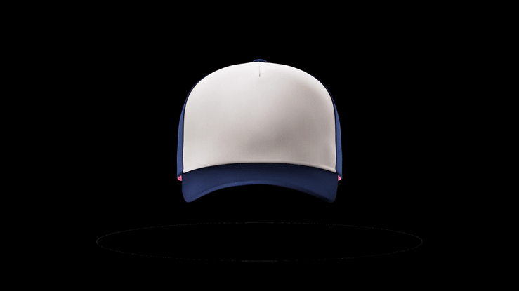 A baseball cap with a white front panel, navy blue brim and backing, and small pink accents on the sides, on a black background.