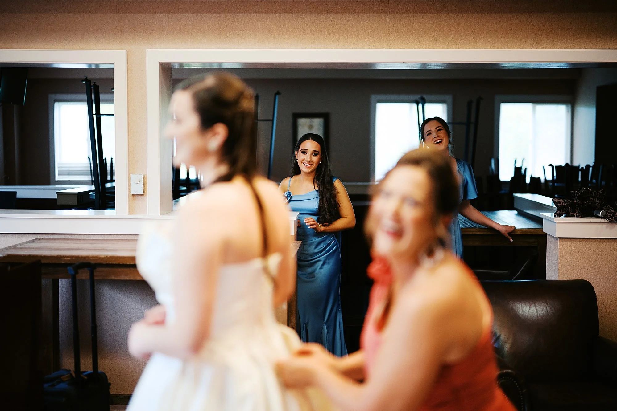 Bridesmaids laughing while bride gets ready at Fasig-Tipton wedding in Lexington KY