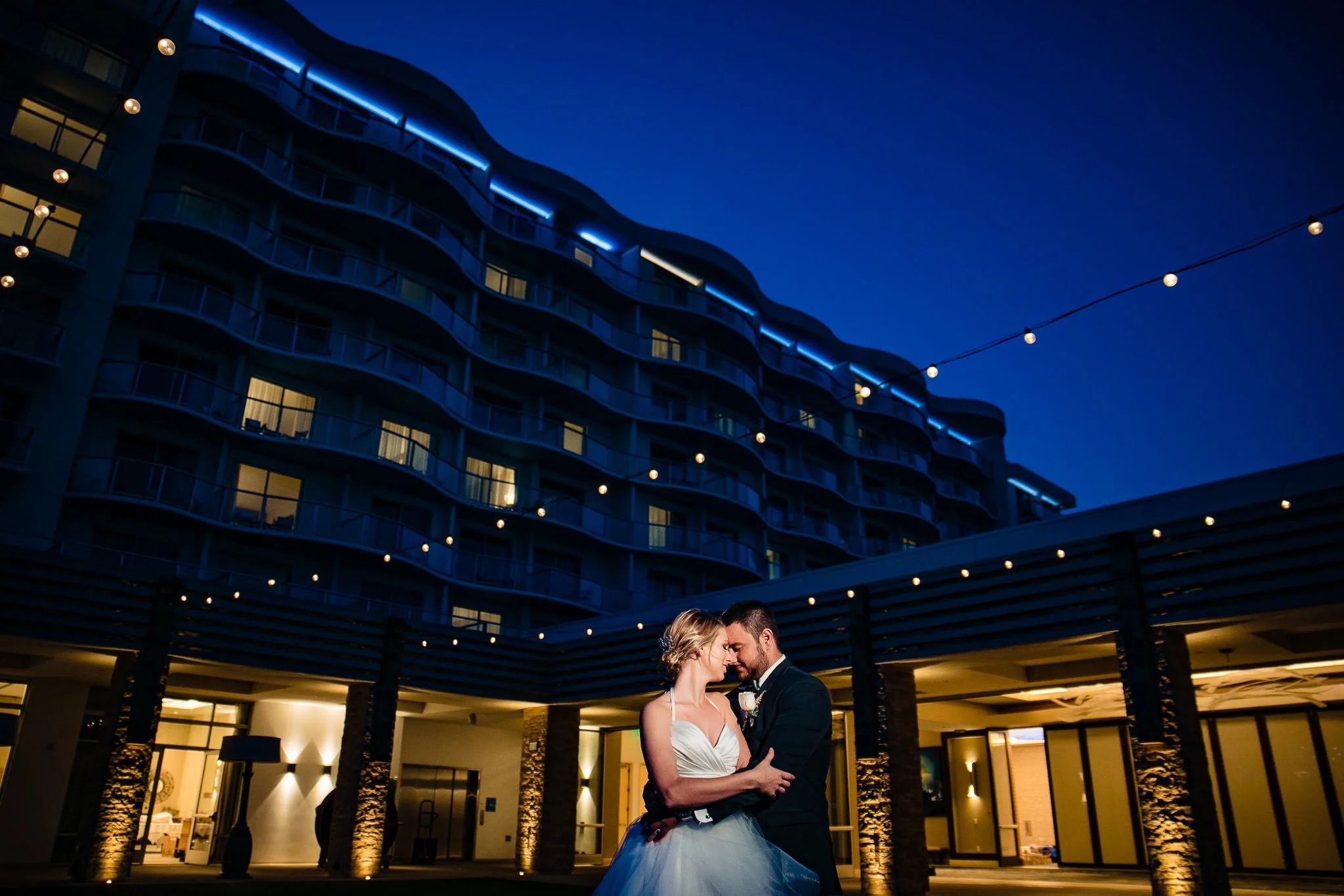 bride and groom night time portrait with pasea hotel architecture in background