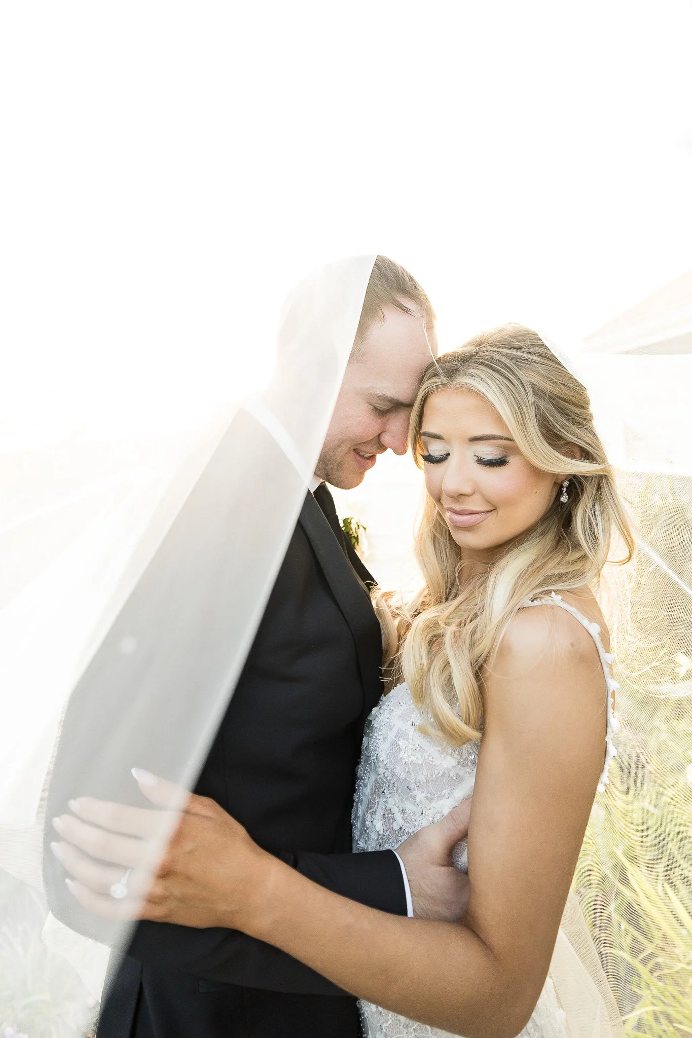 Bride and groom nuzzling under veil Orange County wedding photography