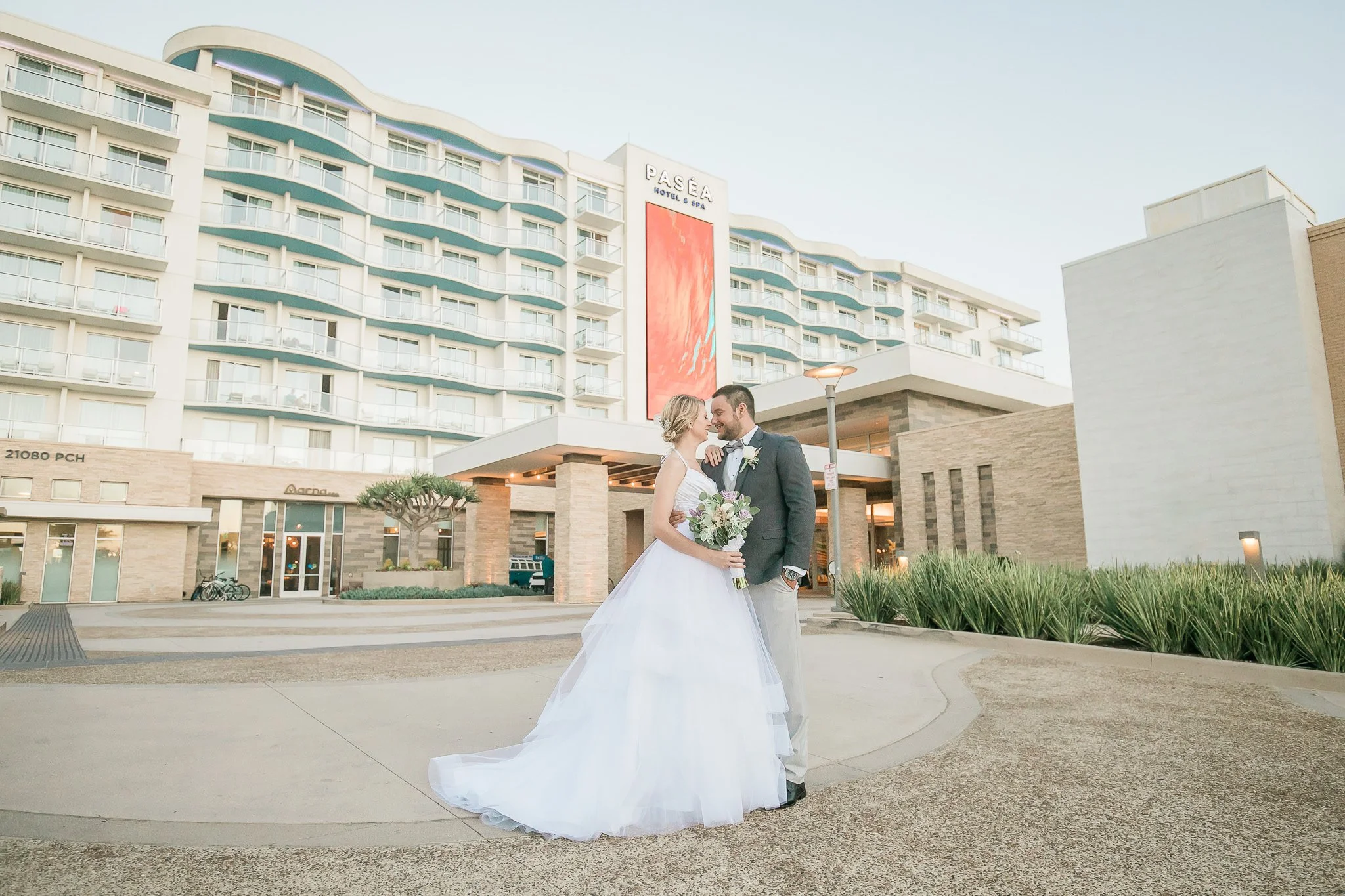 bride and groom portrait outside front of Pasea Hotel in Huntington Beach