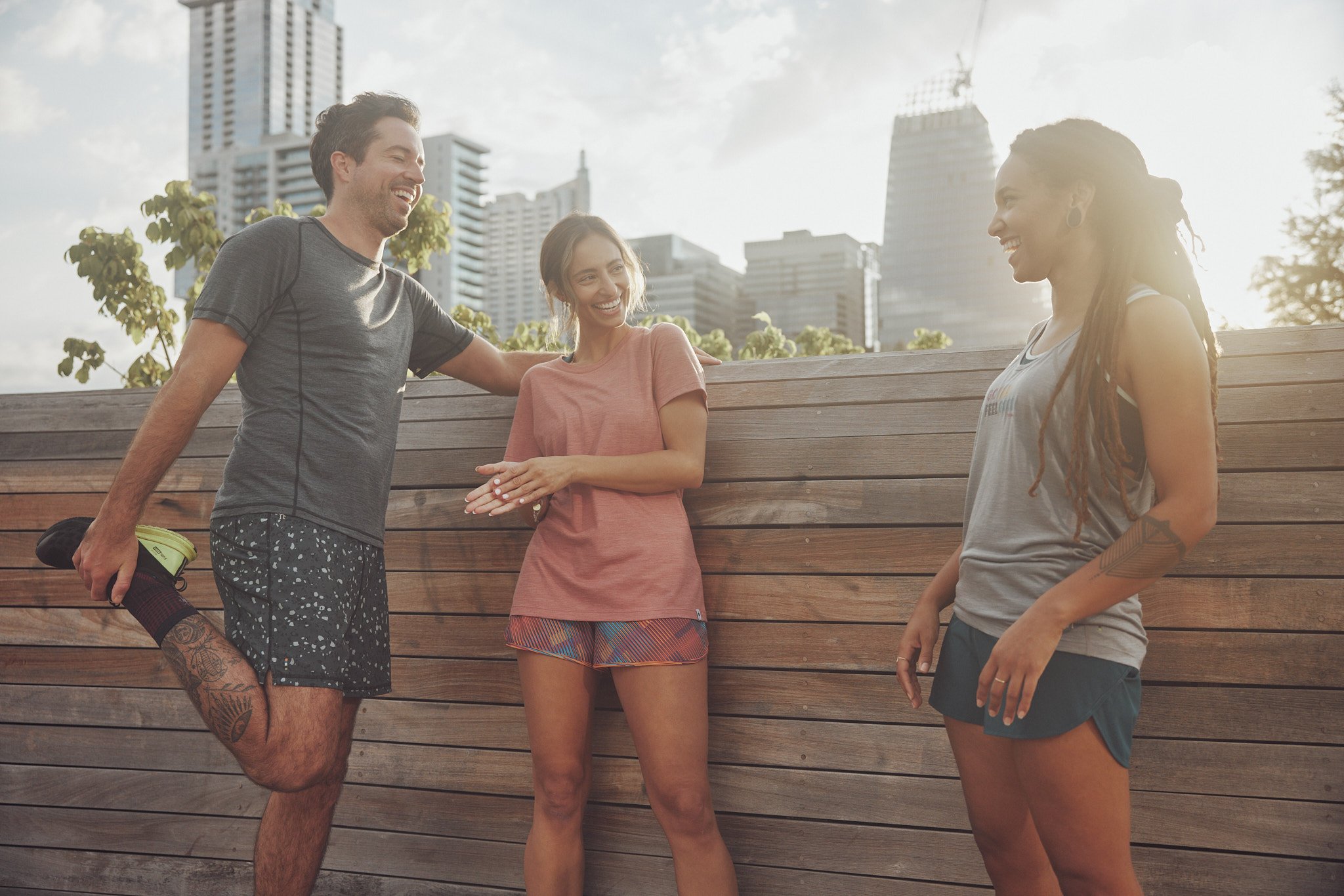 Friends running on a pedestrian bridge with the downtown Austin skyline, Smartwool Spring 2021 campaign, photography by Dag Larson