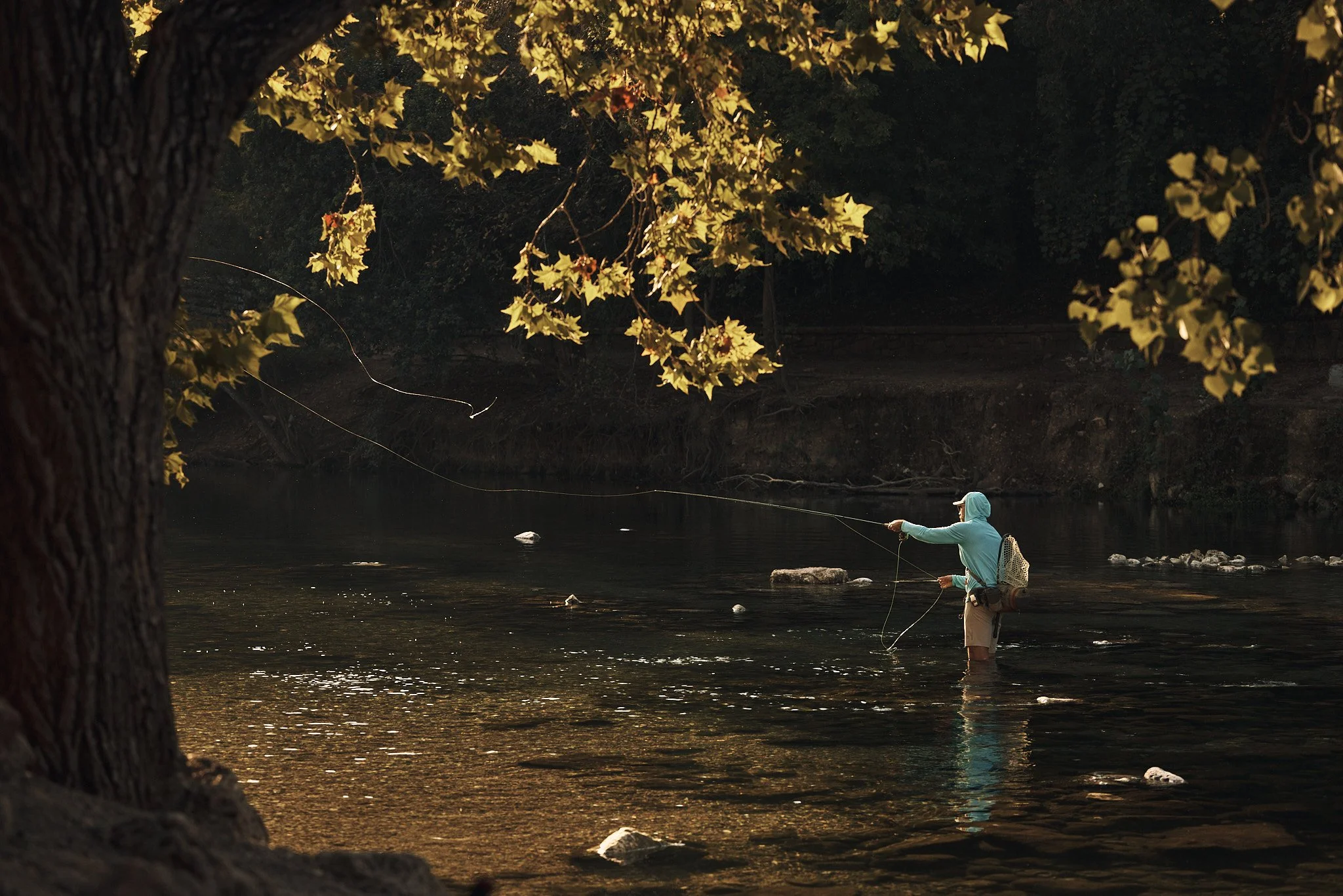 Angler fly fishing a shaded river near Austin, Smartwool Spring 2021 campaign, photography by Dag Larson
