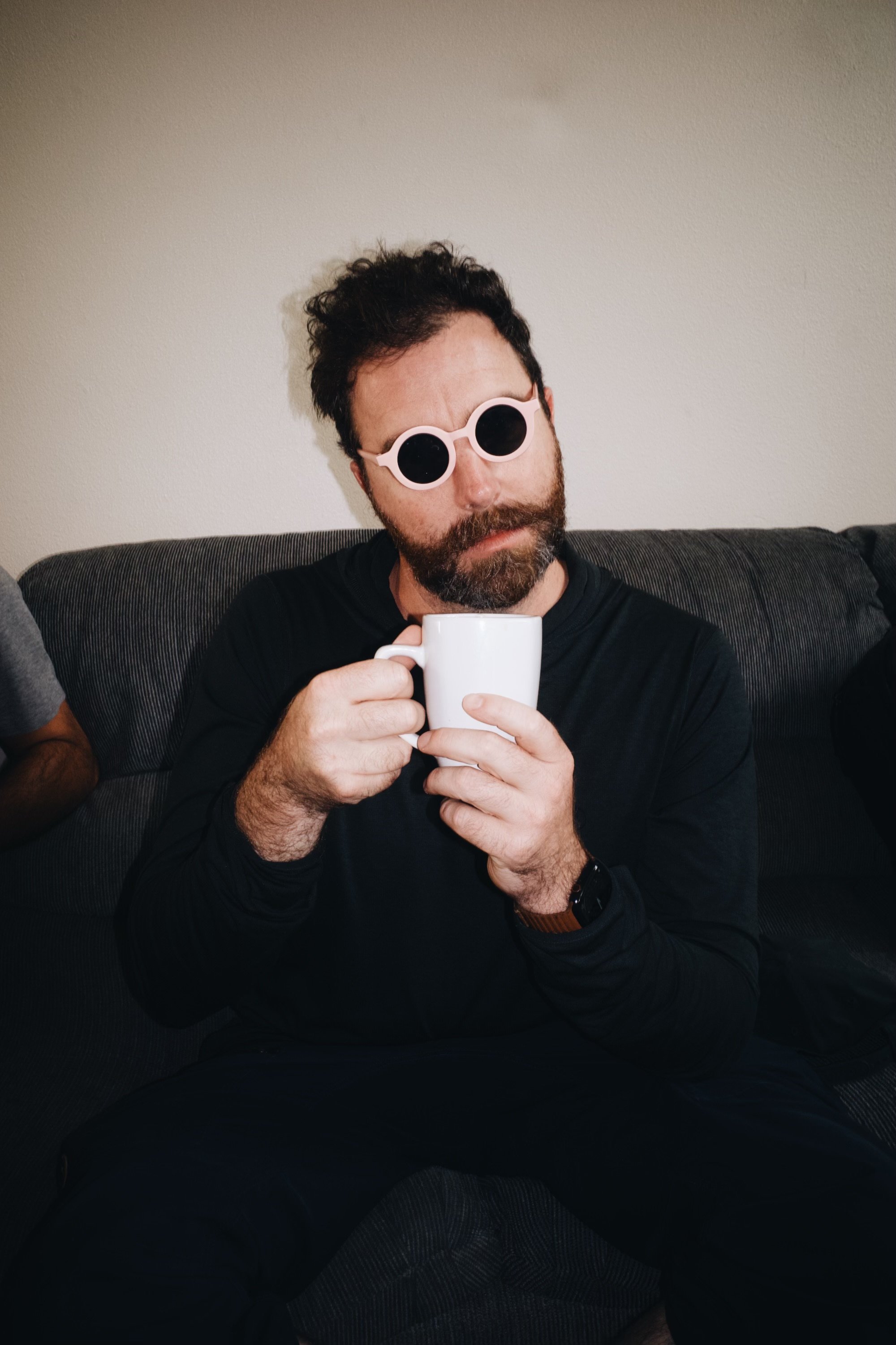 Portrait of Dag Larson with a cup of coffee and round sunglasses