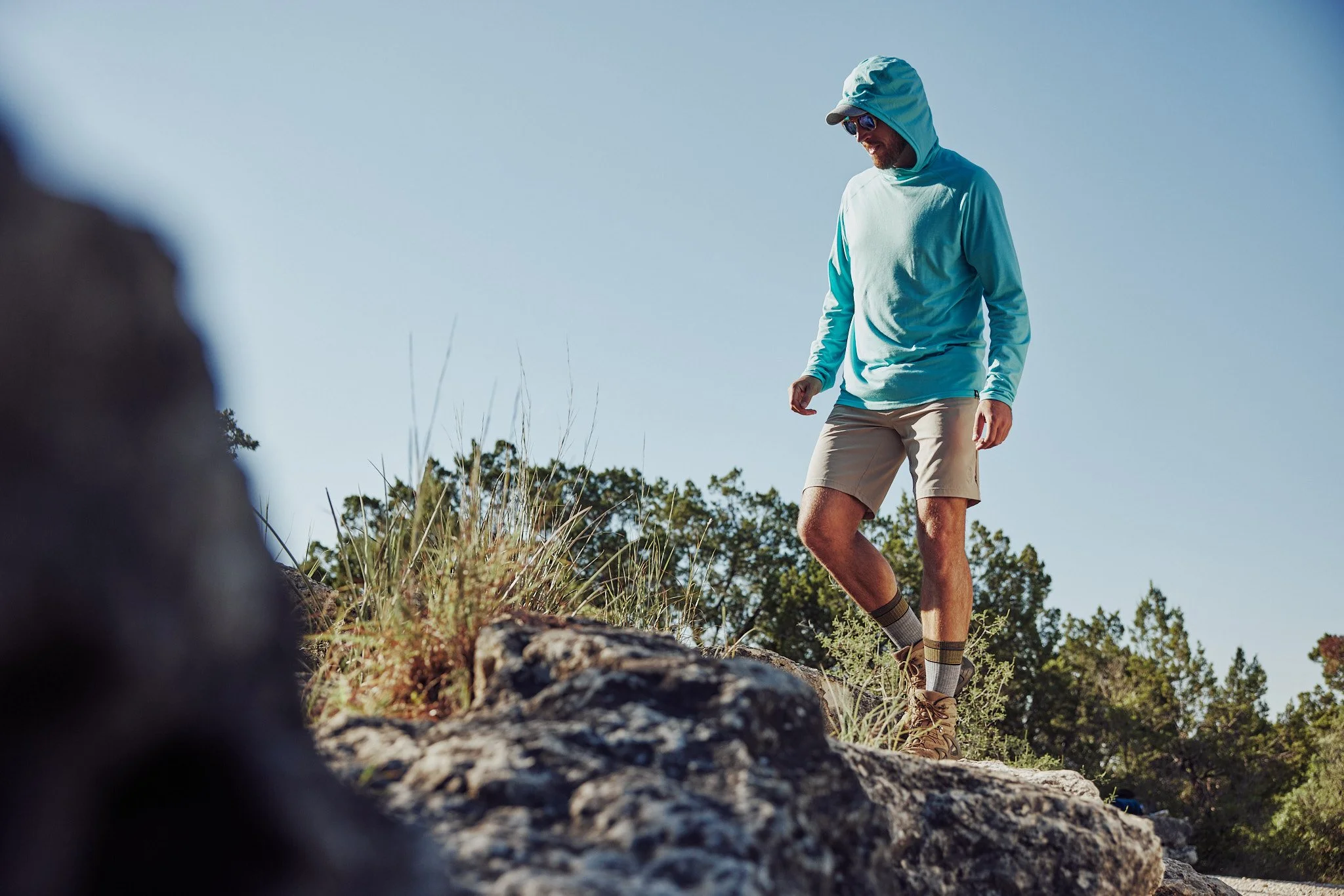 Hiker in a Smartwool sun hoodie on a rocky overlook, Smartwool Spring 2021 campaign, photography by Dag Larson