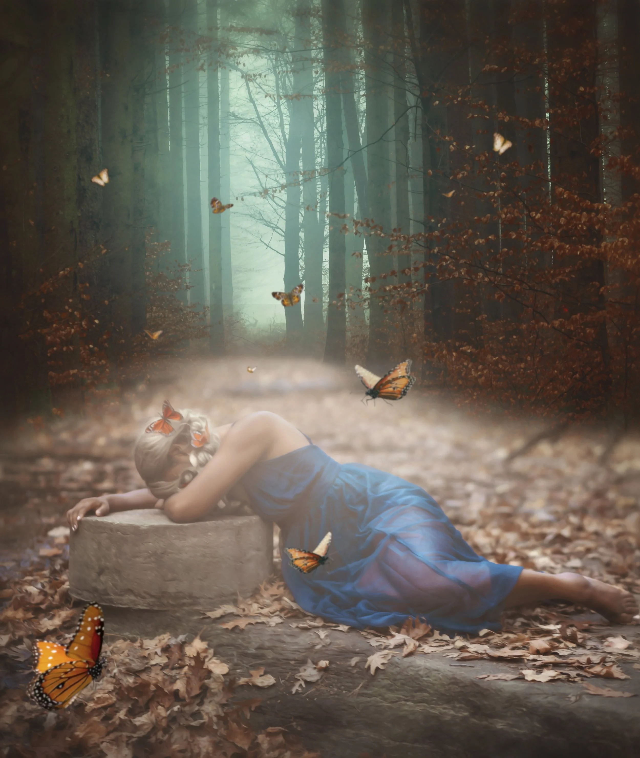 A woman in a blue dress reclining on the ground in a forest surrounded by orange butterflies