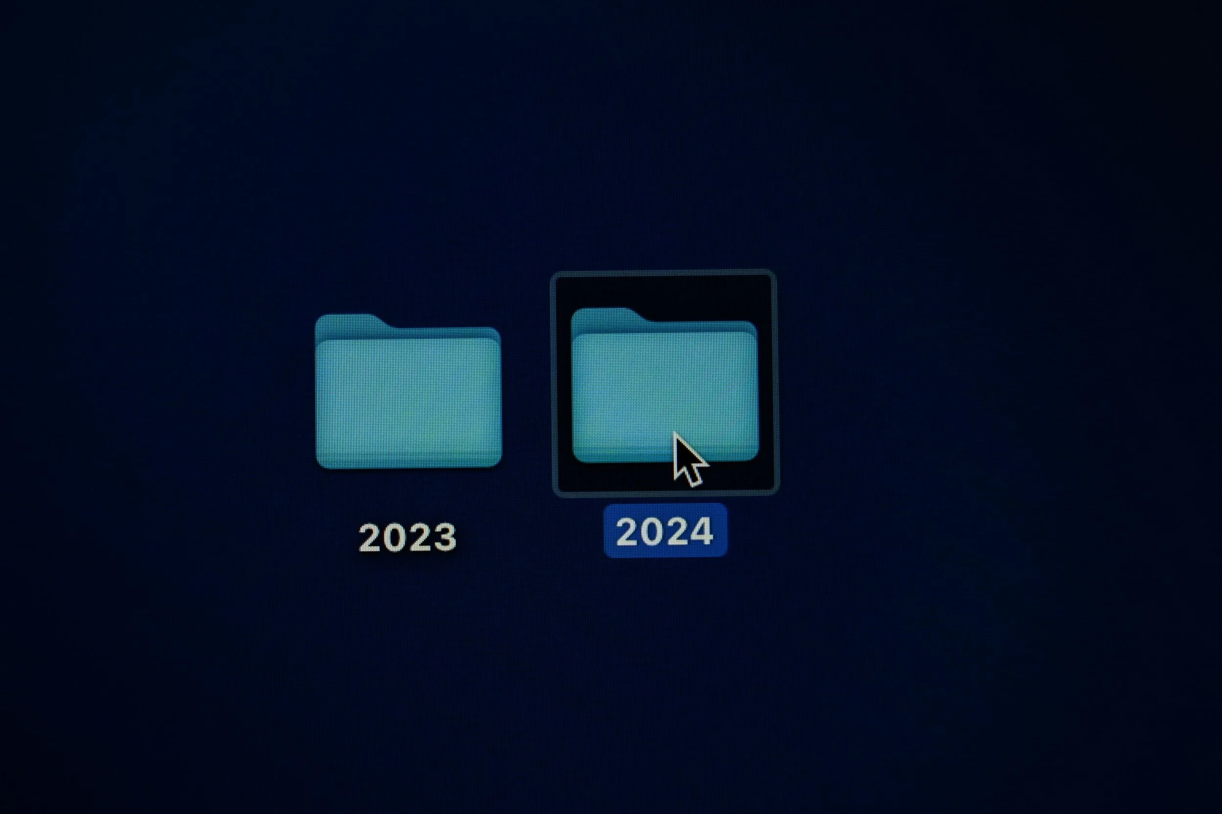 Computer screen showing two folder icons labeled 2023 and 2024, with the cursor selecting the 2024 folder.