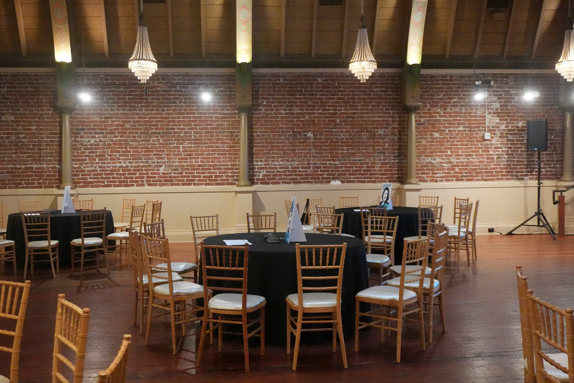 Close-up of event table settings featuring Natural Wood Chiavari Chairs.