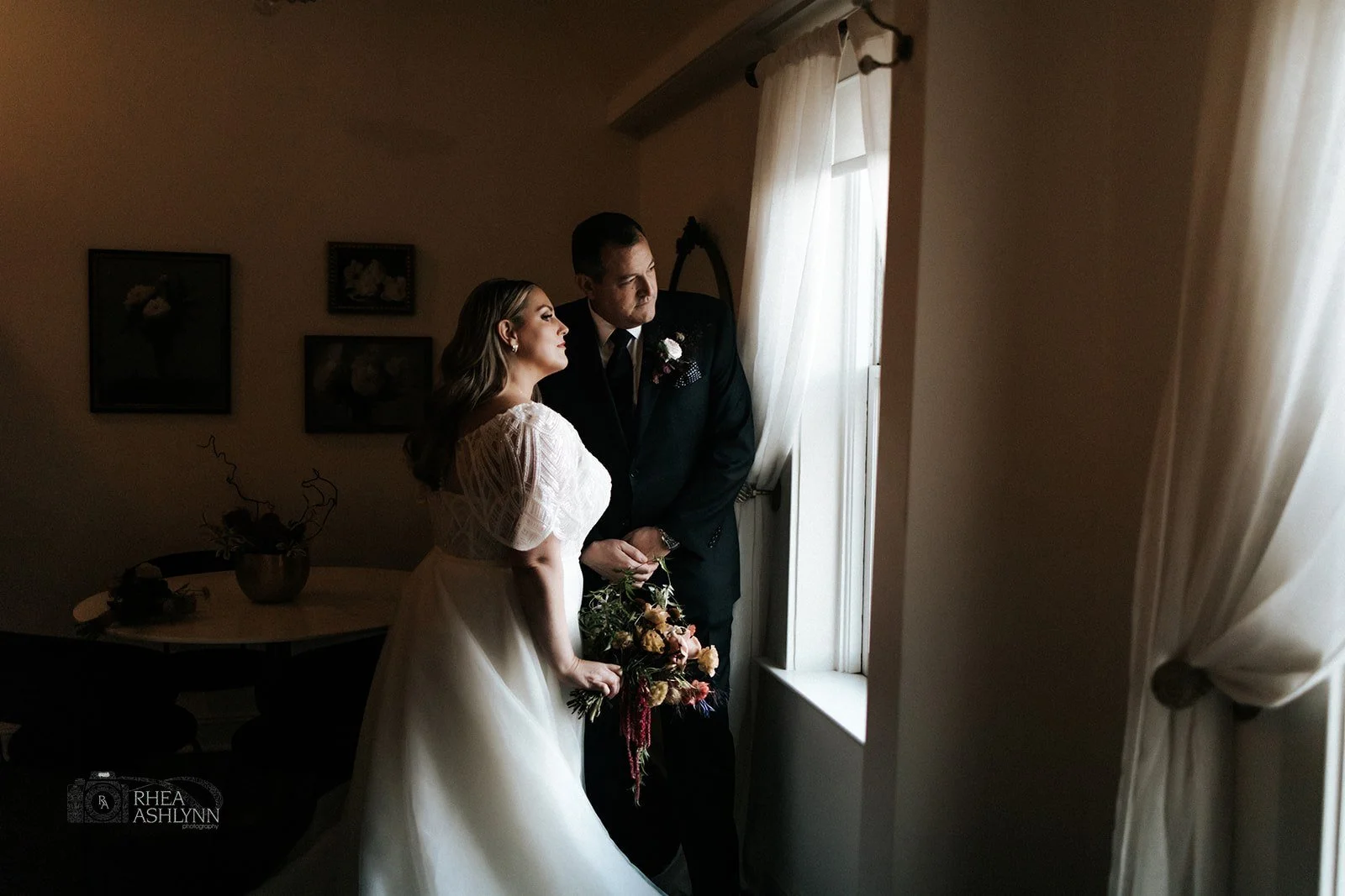 Bride and groom looking at window