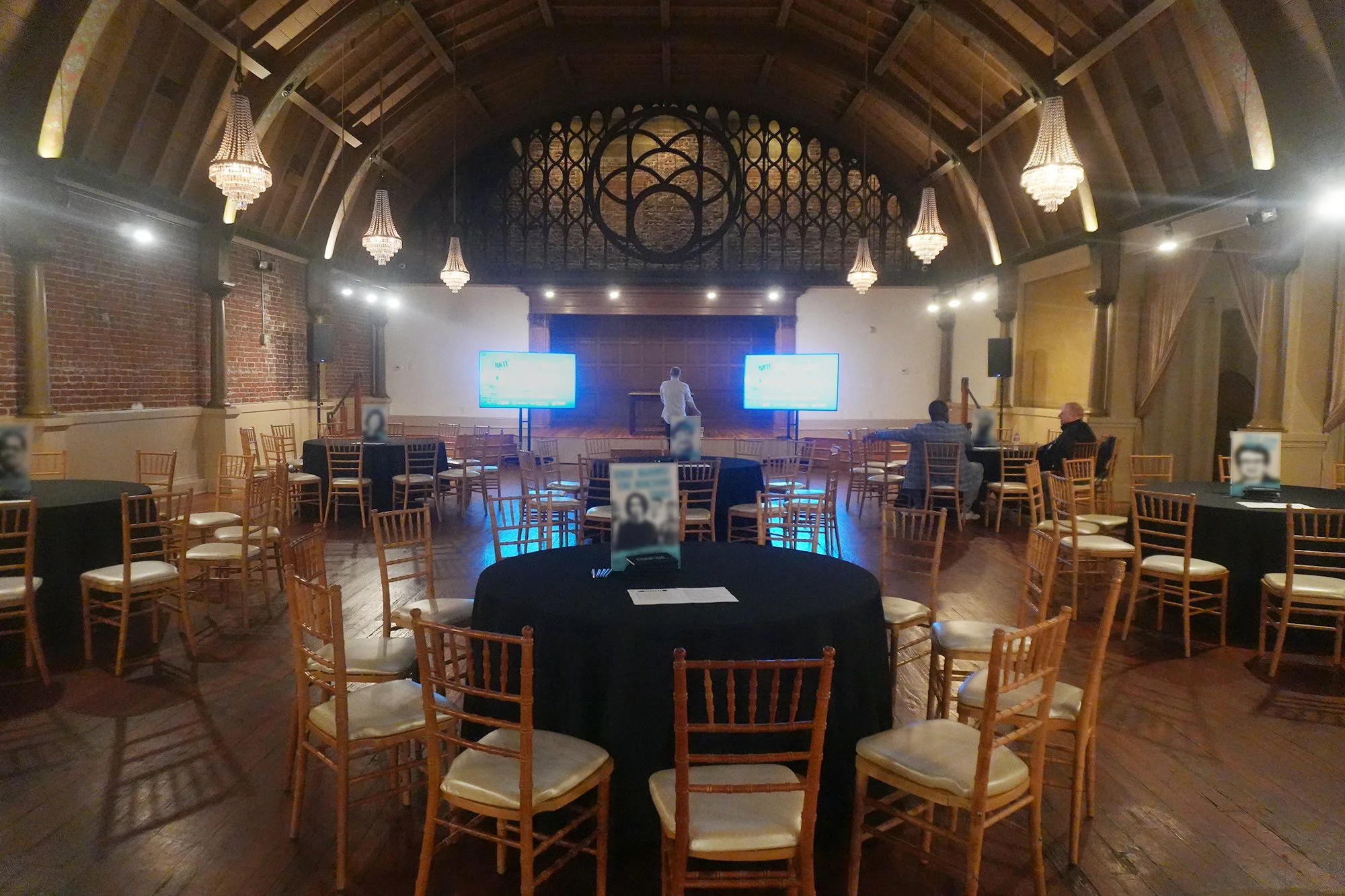 Elegant Natural Wood Chiavari Chairs arranged at tables in a bright venue.