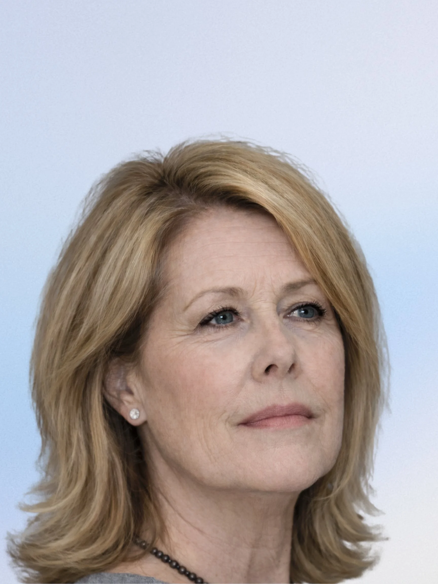 Black and white portrait of a smiling man with short hair, wearing a collared shirt, outdoors with blurred trees in the background.