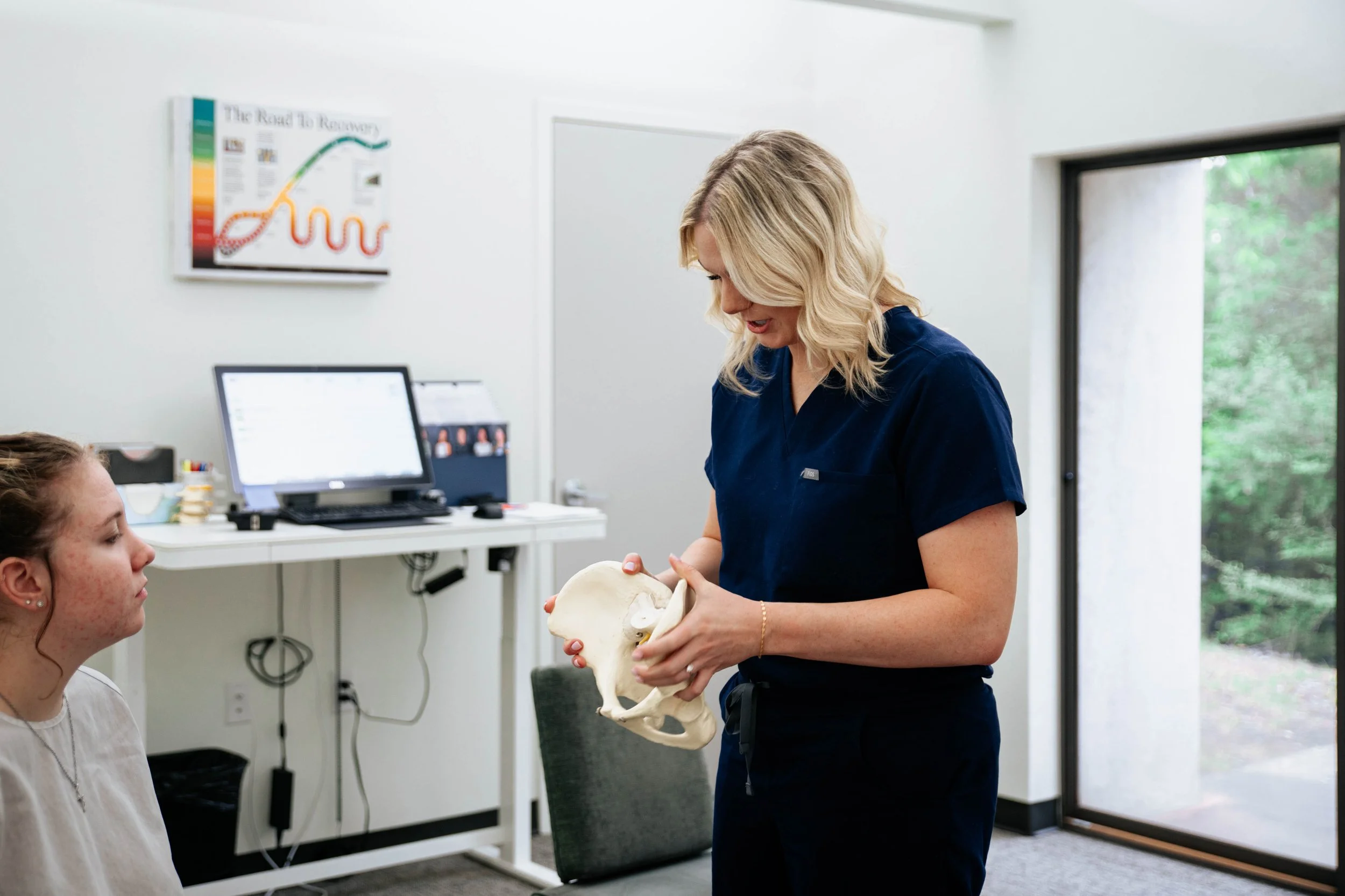 Staff worker showing a skeletal model to a patient