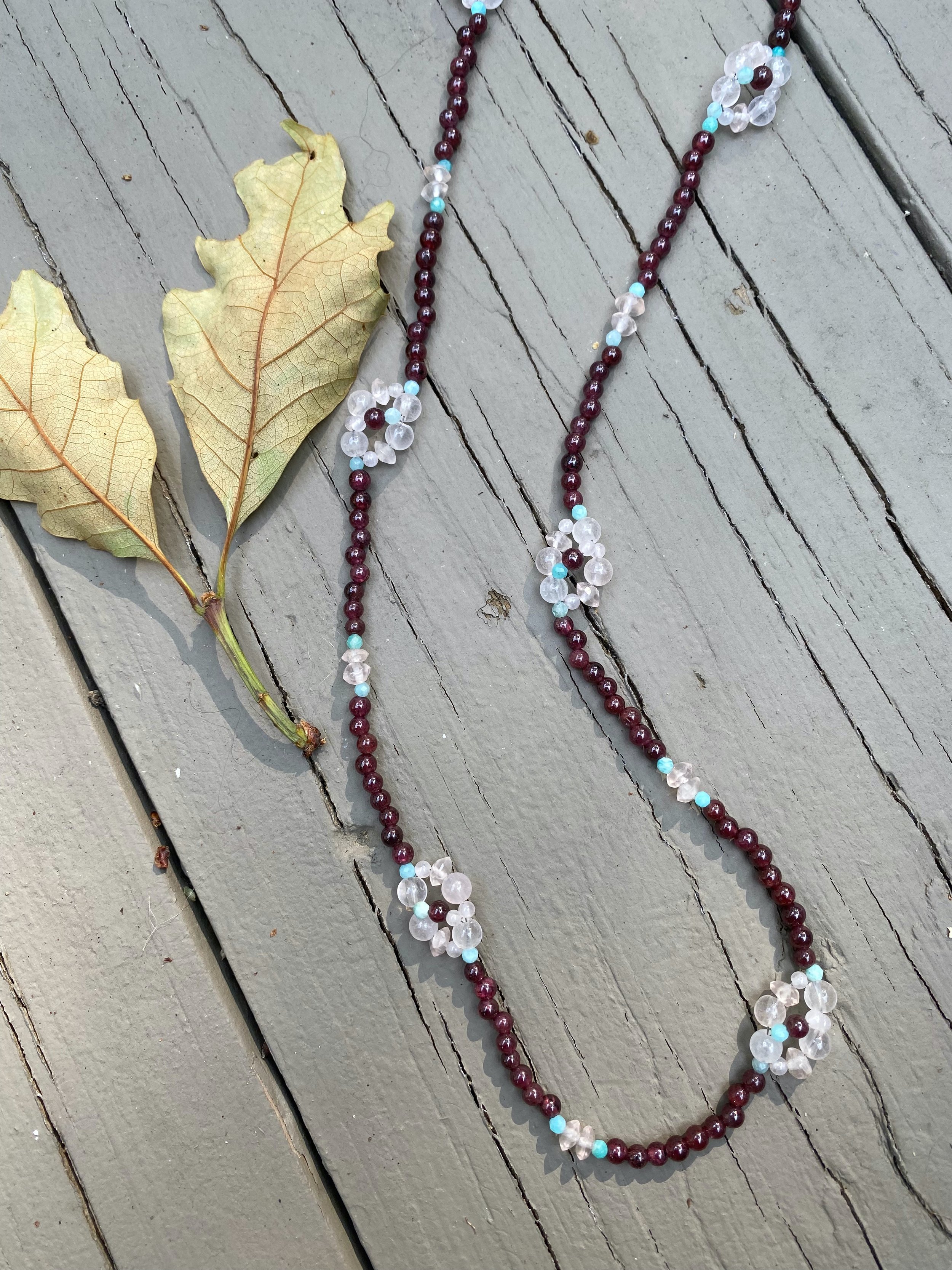 Apatachi handcrafted jewelry sophisticated bohemian necklace with pretty Rose Quartz Wildflowers on a long necklace of Garnet gemstones with Amazonite and pyrite in this beautiful necklace.