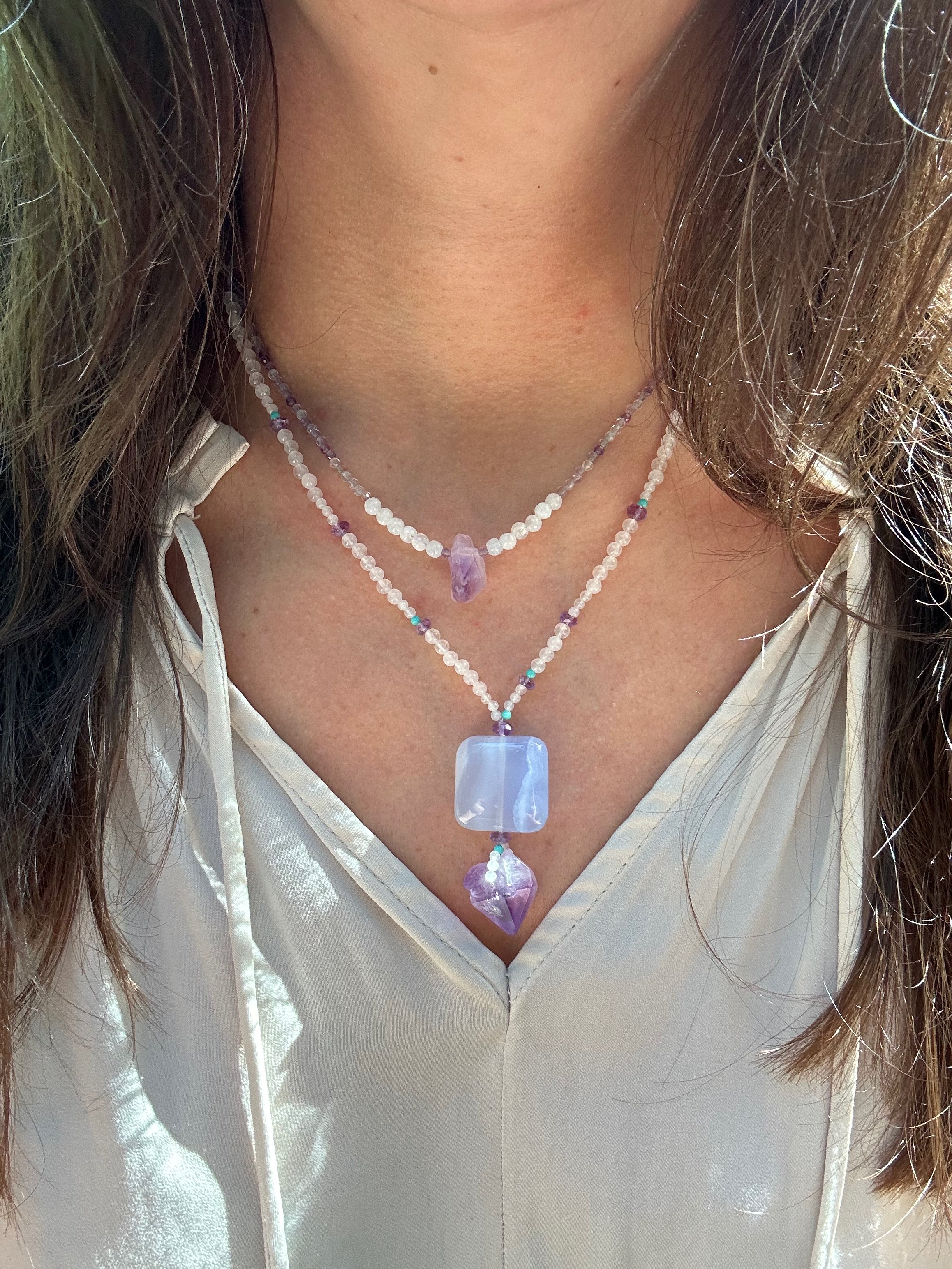 Apatachi handcrafted jewelry sophisticated bohemian necklace with raw amethyst smooth square-shaped chalcedony gemstones. This bohemian centerpiece is balanced by a rose quartz and turquoise necklace.