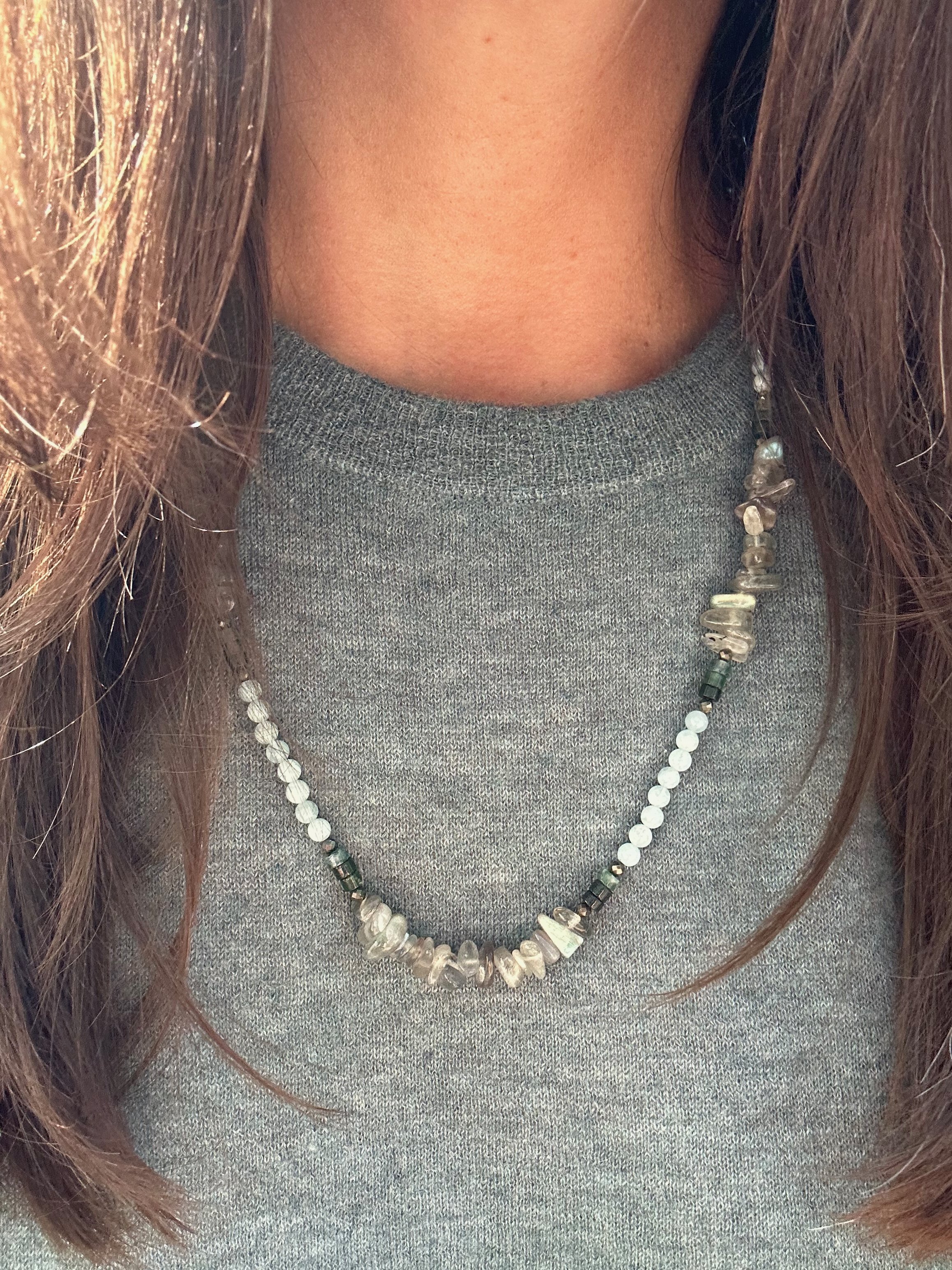 Reflective Labradorite chips are highlighted in sections by heishi Moss Agate, Aquamarine and Pyrite in this beautifully balanced handmade necklace, worn on a earthy teal cashmere shirt