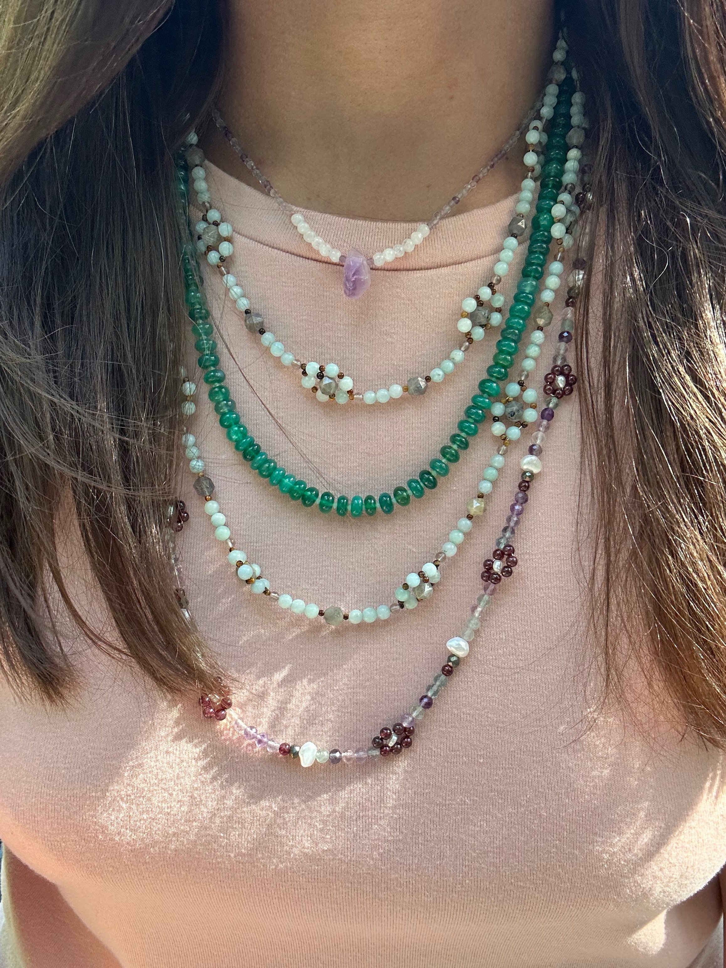 Green Onyx Strand Necklace with Aquamarine. Onyx stones are smooth and catch the light beautifully on a light pink tshirt layered with many necklaces