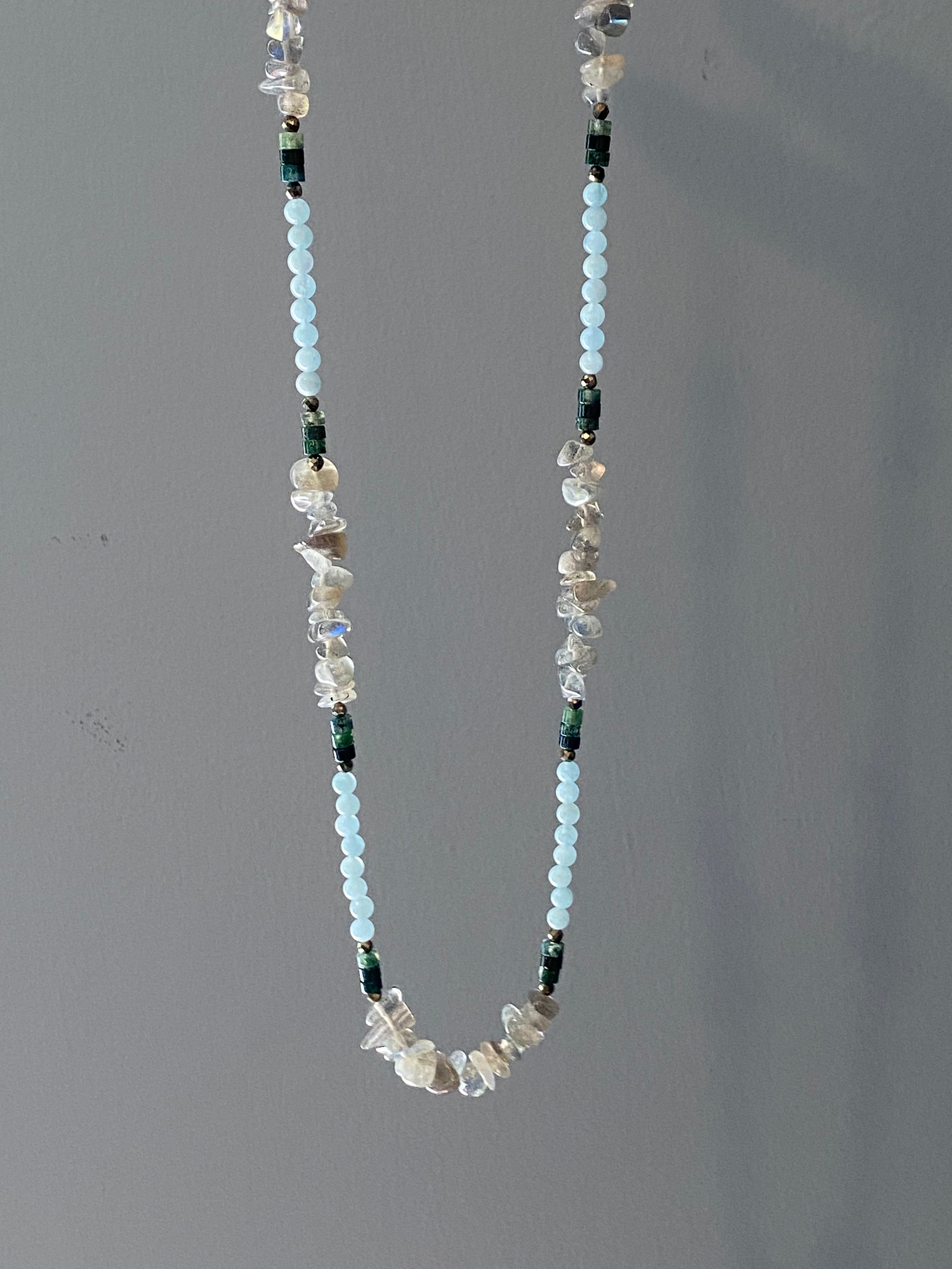 Reflective Labradorite chips are highlighted in sections by heishi Moss Agate, Aquamarine and Pyrite in this beautifully balanced handmade necklace.