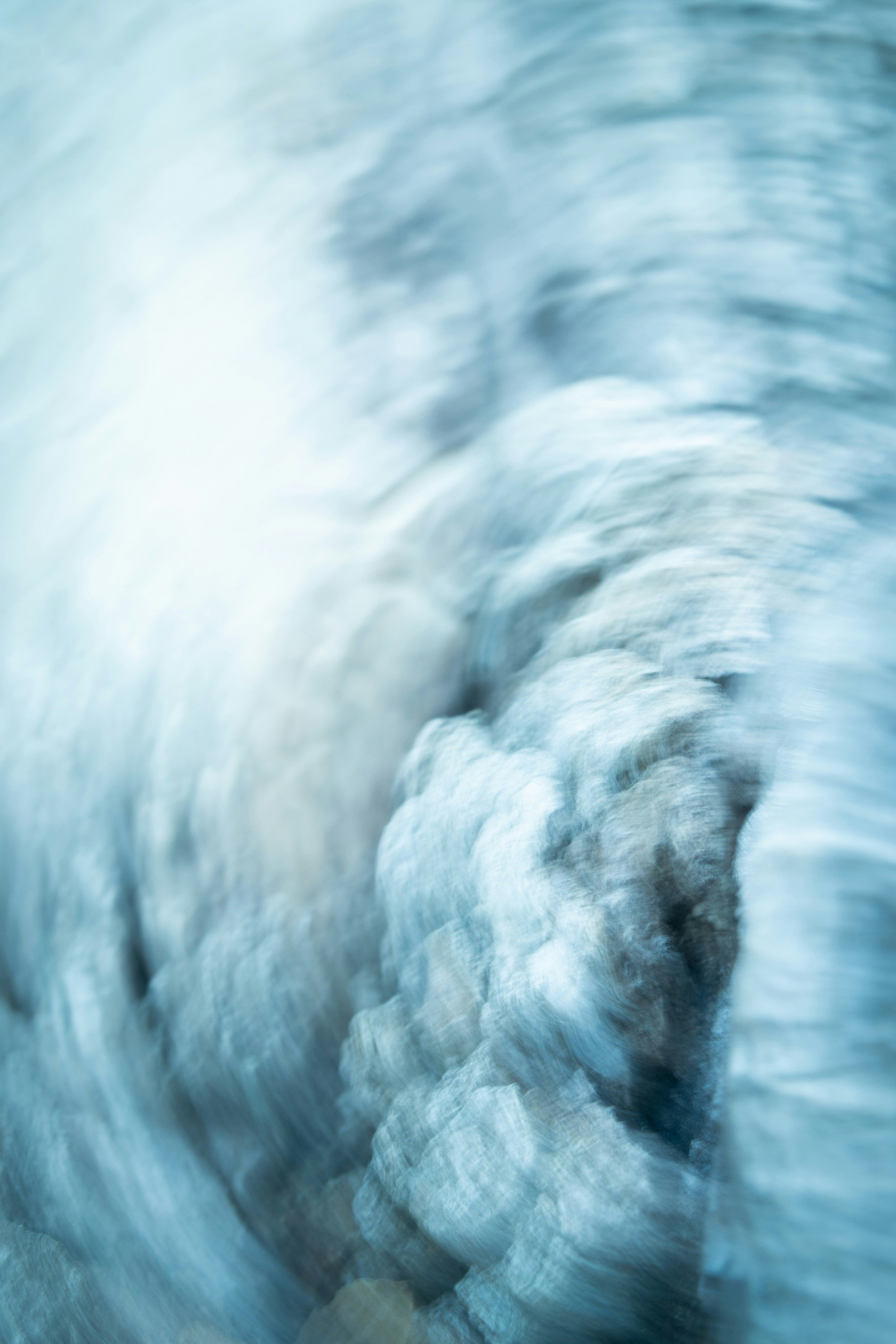 A blurred close-up of ice or snow with a cool blue color palette.