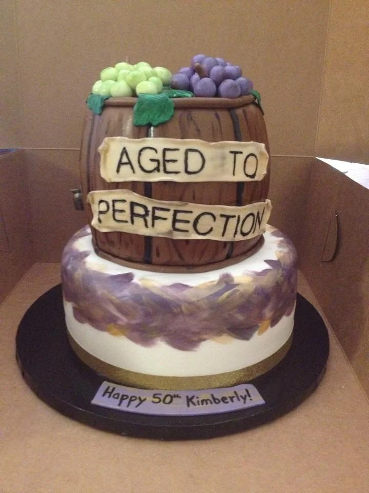 Rustic wine barrel cake with grapes and 'aged to perfection' design