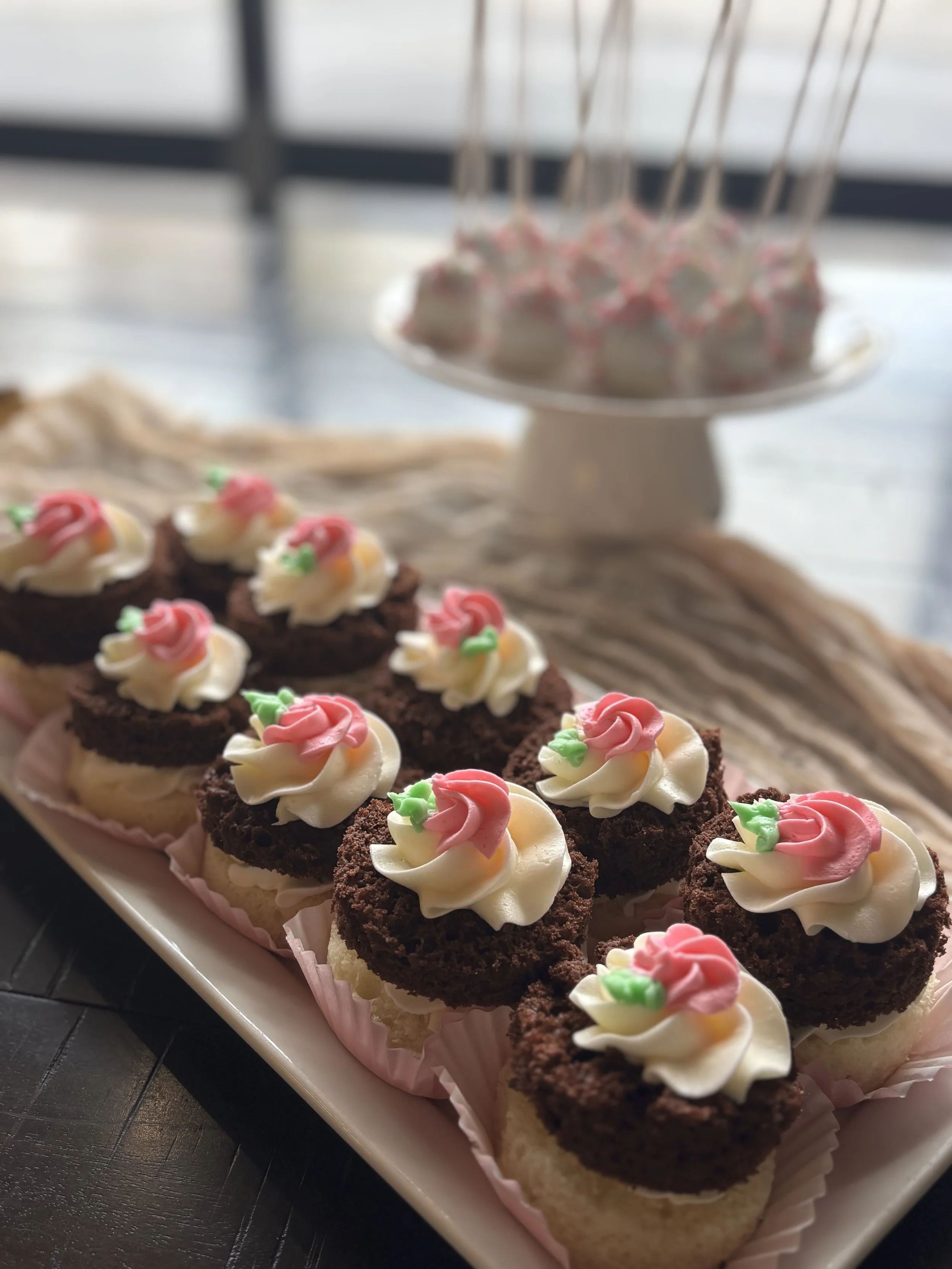 Baby shower mini cakes in chocolate and vanilla with buttercream and a pink rosette